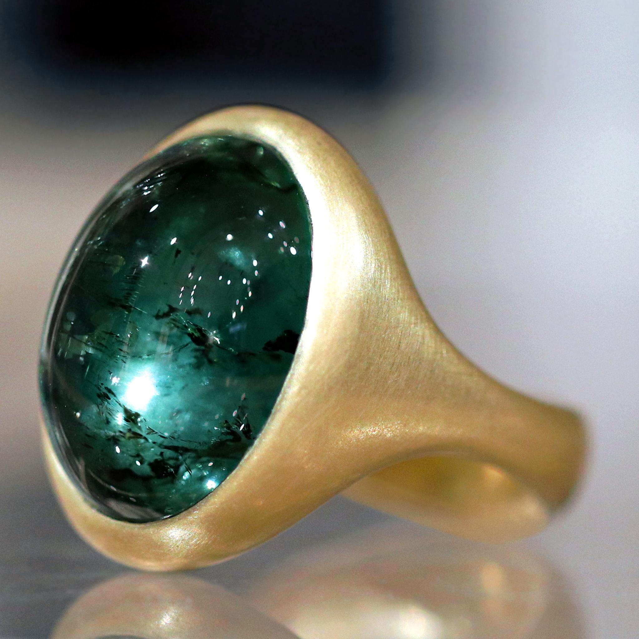 One of a Kind Ring hand-fabricated by jewelry maker Lola Brooks featuring an extraordinary glowing 23.69 carat lush blue green tourmaline cabochon bezel-set in the artist's signature cast and intricately-finished 18k yellow gold. Size 6.5 (can be
