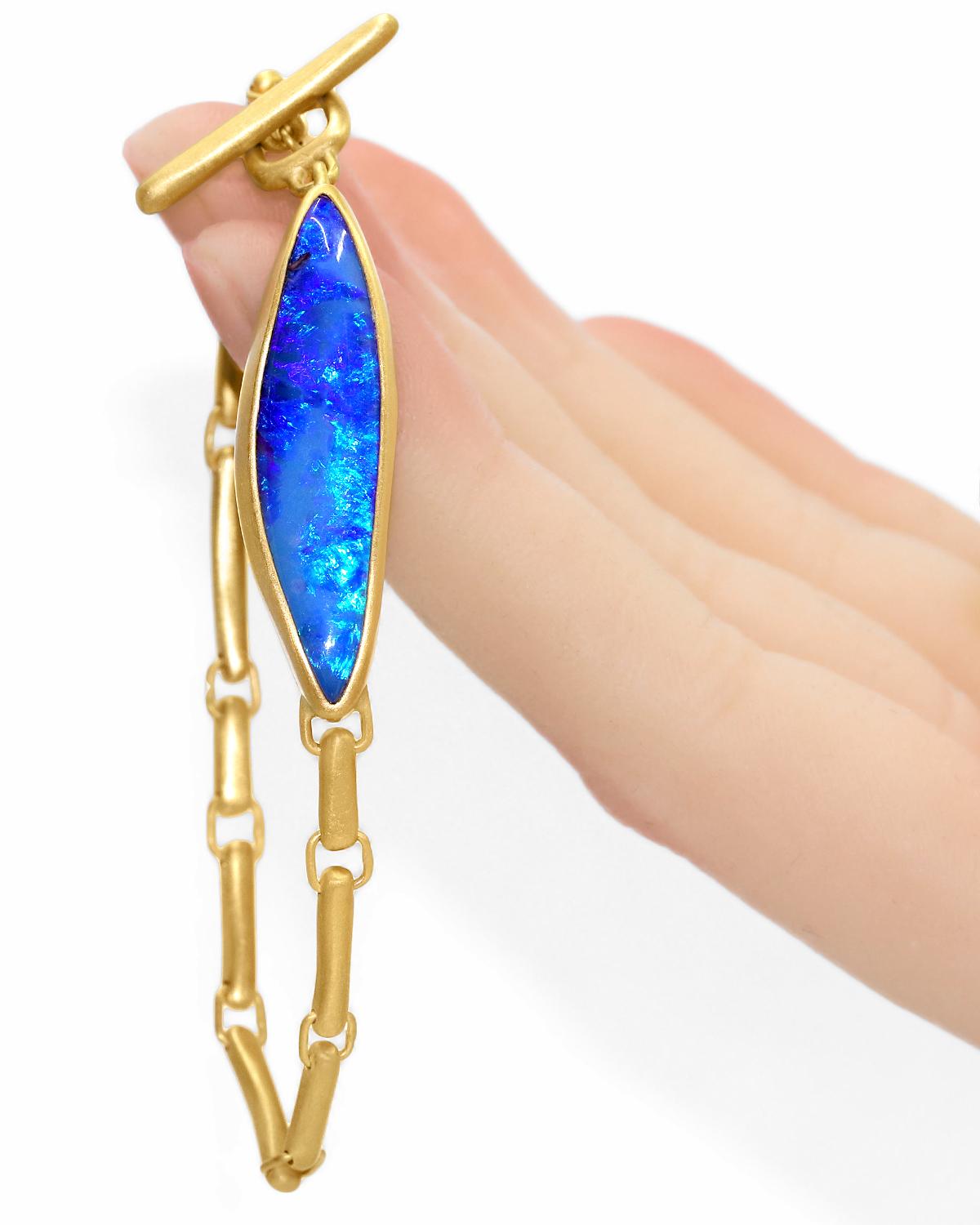 One of a Kind ID Bracelet by jewelry maker Lola Brooks hand-fabricated in matte-finished 22k yellow gold showcasing a phenomenal 11.75 carat deep blue solid Australian Boulder Opal with fantastic neon green, neon blue, and violet color play, set in