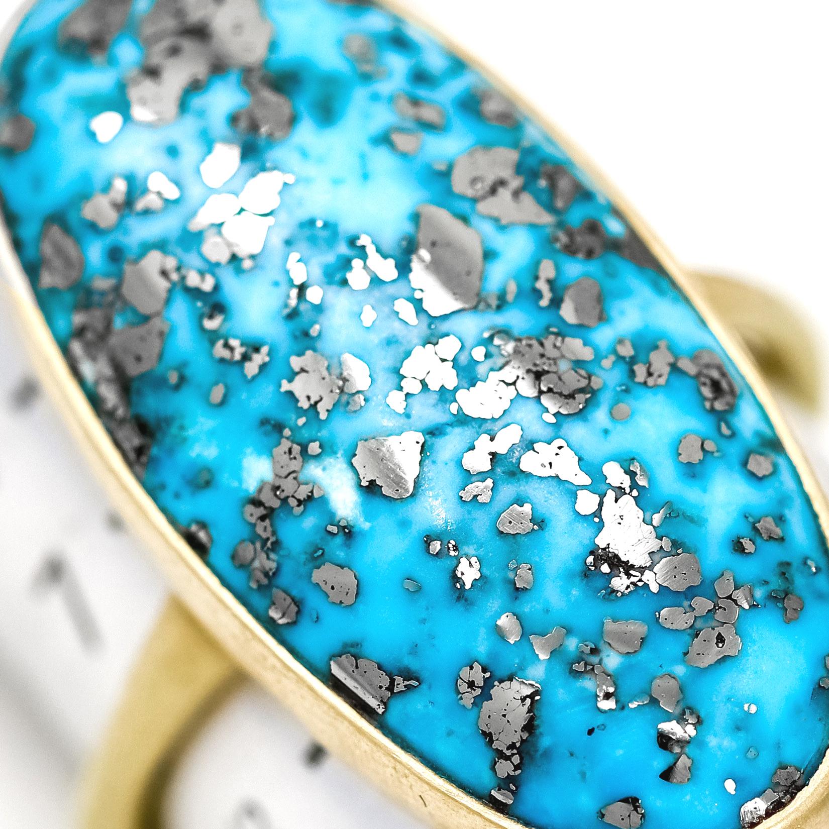 One of a Kind Ring hand-fabricated by jewelry maker Lola Brooks featuring an extraordinary 16.81ct oval turquoise cabochon that beautifully exhibits a natural metallic Pyrite matrix, providing a distinctive mirrored effect to the gemstone. The
