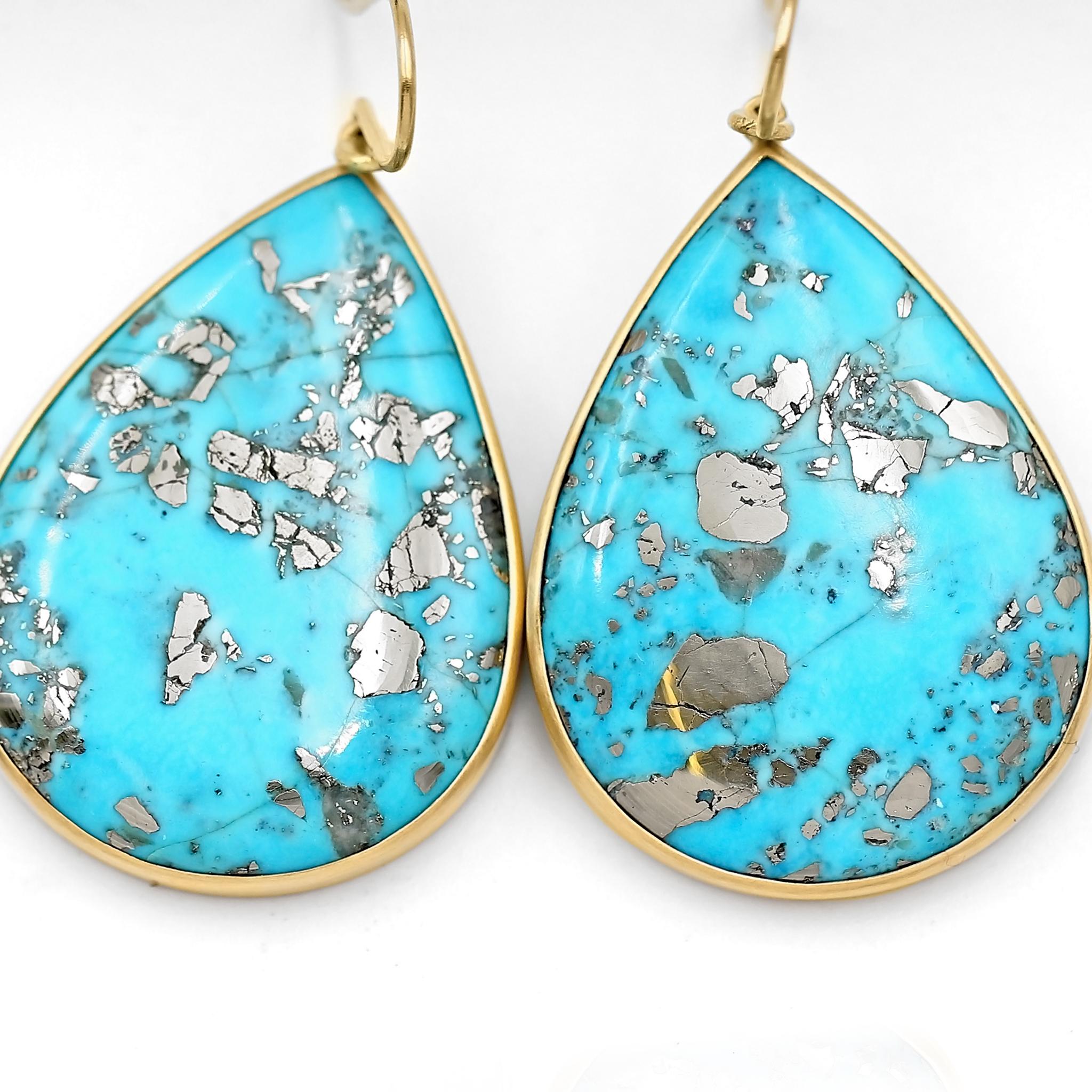 One of a Kind Earrings hand-fabricated by jewelry maker Lola Brooks showcasing a matched pair of top quality natural turquoise cabochon drops totaling 64.68 carats, and featuring a shimmering metallic iron pyrite matrix atop a vibrant blue backdrop.