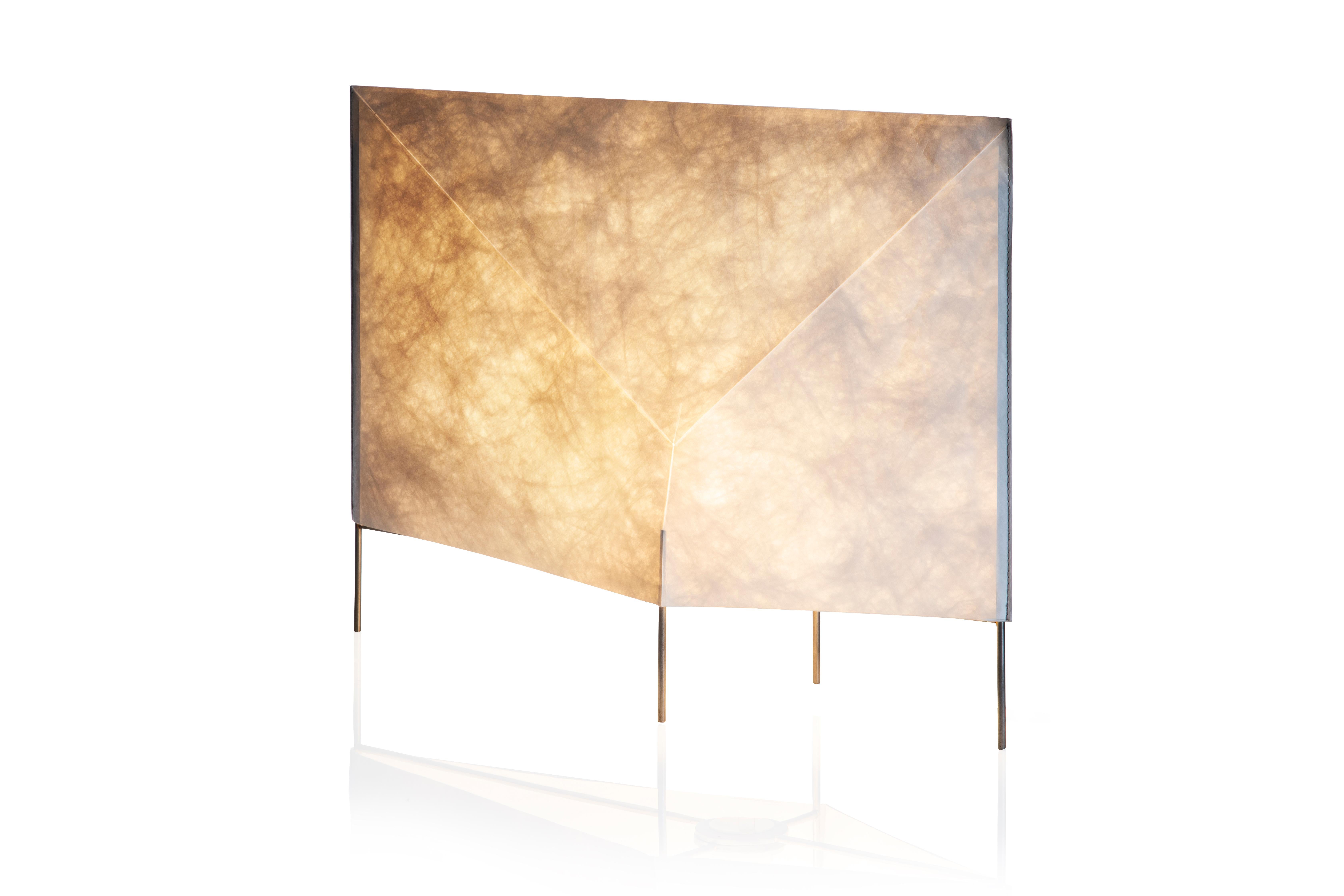 Simple and light table lamp; remember an illuminated envelope. Composed of an iron frame and an external tyvek paper coating.