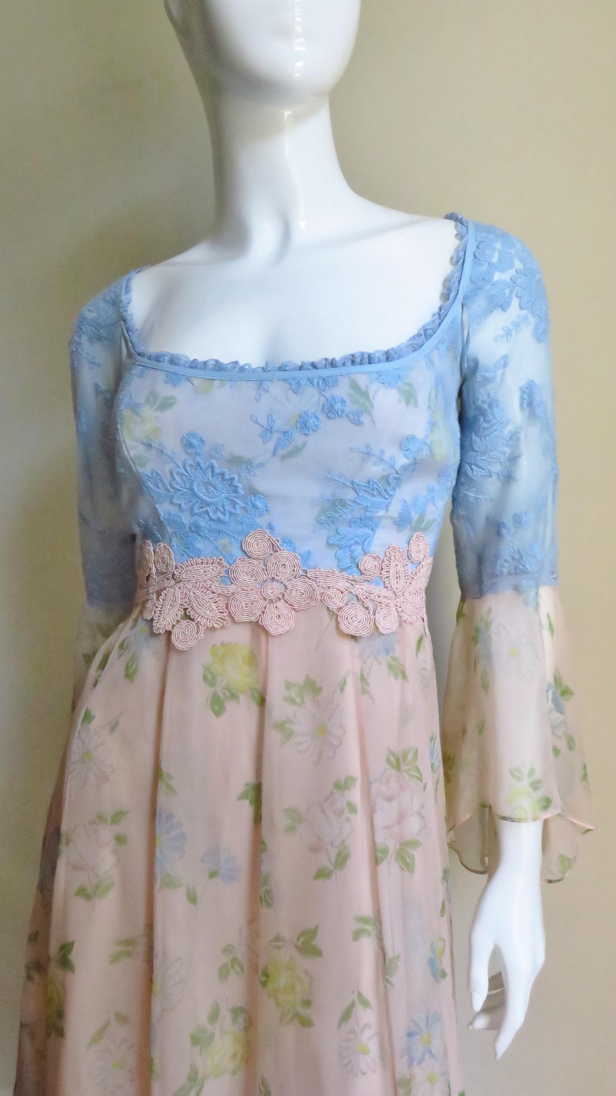 A beautiful ethereal blue and peach silk dress from French designer Lolita Lempicka.  A great combination of a blue lace fitted bodice and upper sleeves with a light peach silk with a yellow and blue flower pattern skirt and lower bell sleeves. The