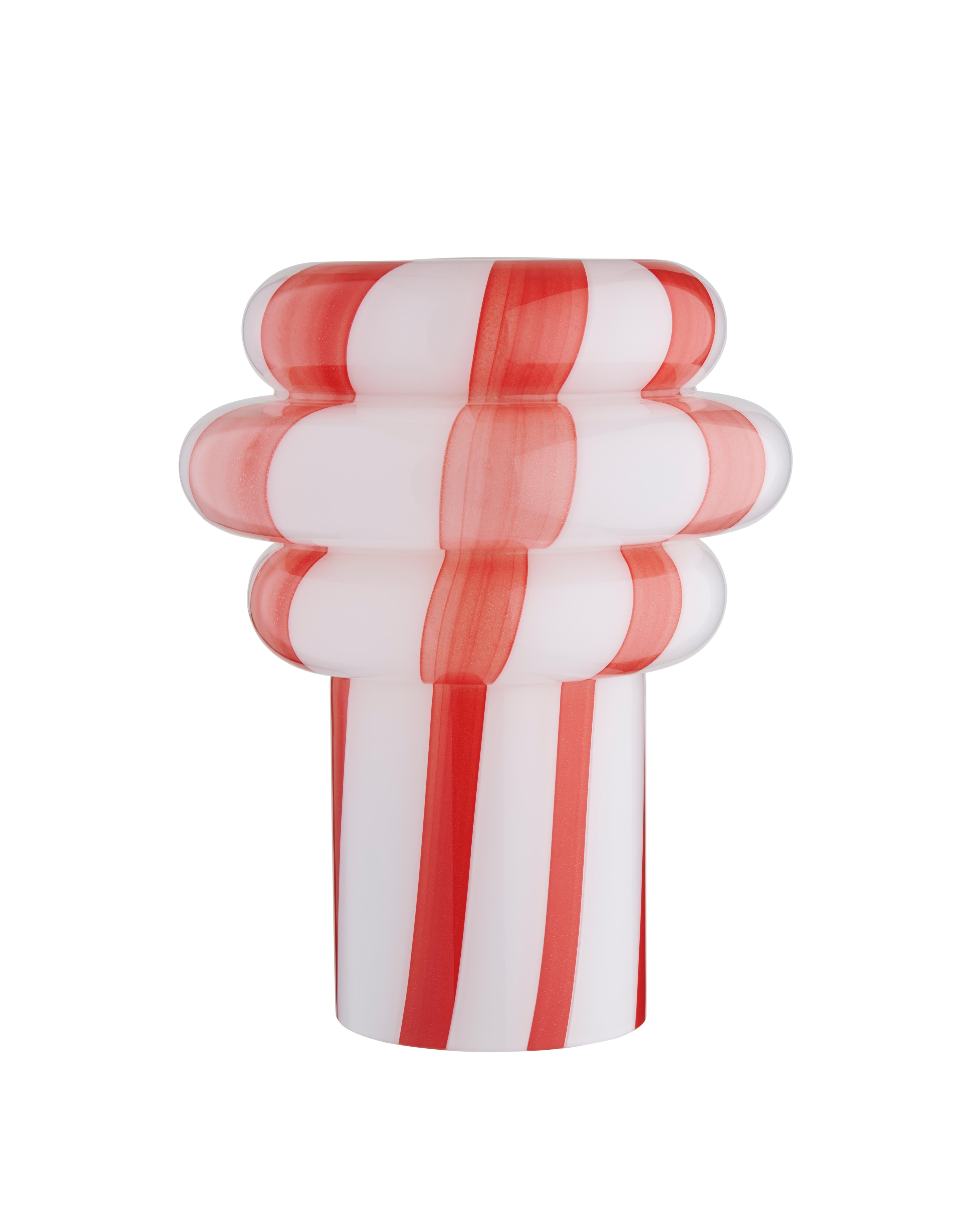 Lolli è un oggetto di illuminazione scultoreo realizzato interamente in vetro, sapientemente lavorato con tecniche tradizionali di soffiatura a bocca da abili artigiani.
La sua silhouette ispirata alle caramelle combina curve morbide con una