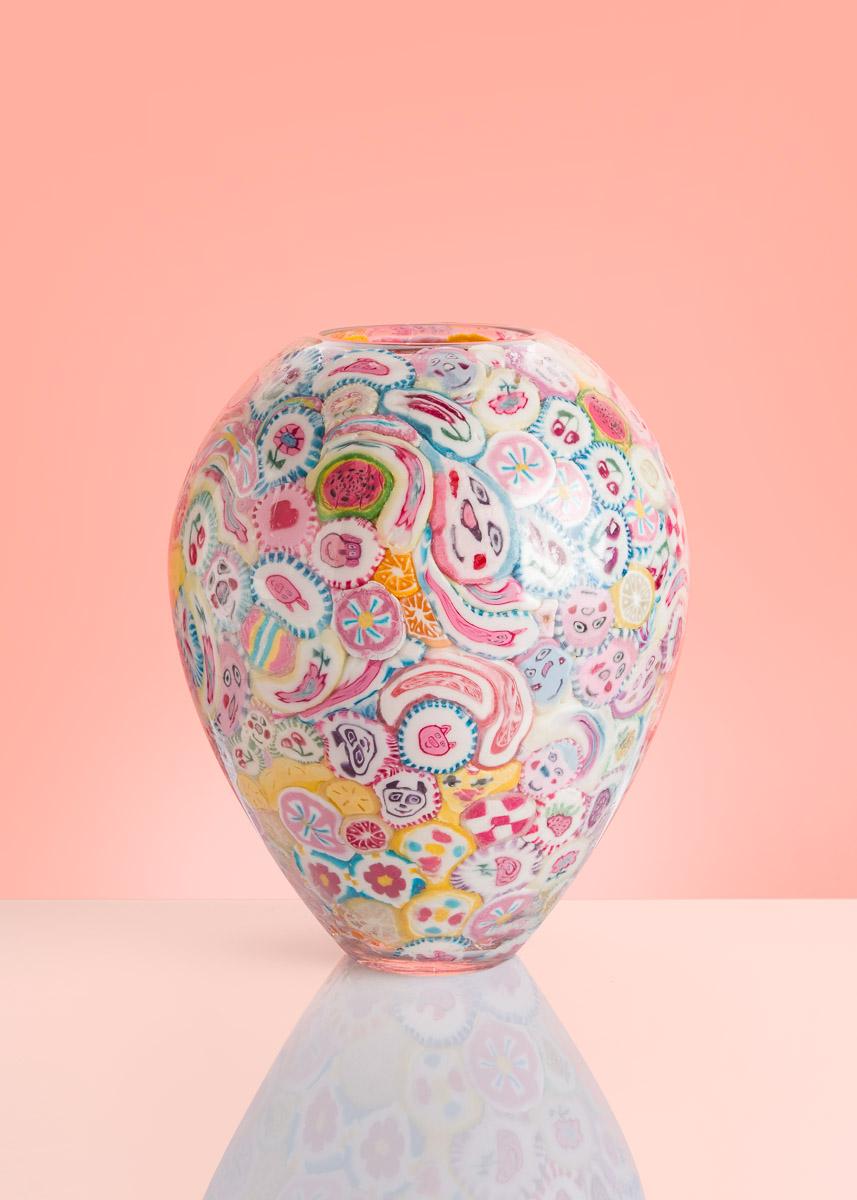 I vasi lecca-lecca sono i pezzi d'arte più iconici di Anna Jozova. È una reazione umoristica alla costosa e impegnativa tecnica del vetro di Murano. I lecca-lecca sono incollati all'interno della forma di cristallo soffiato a mano e successivamente