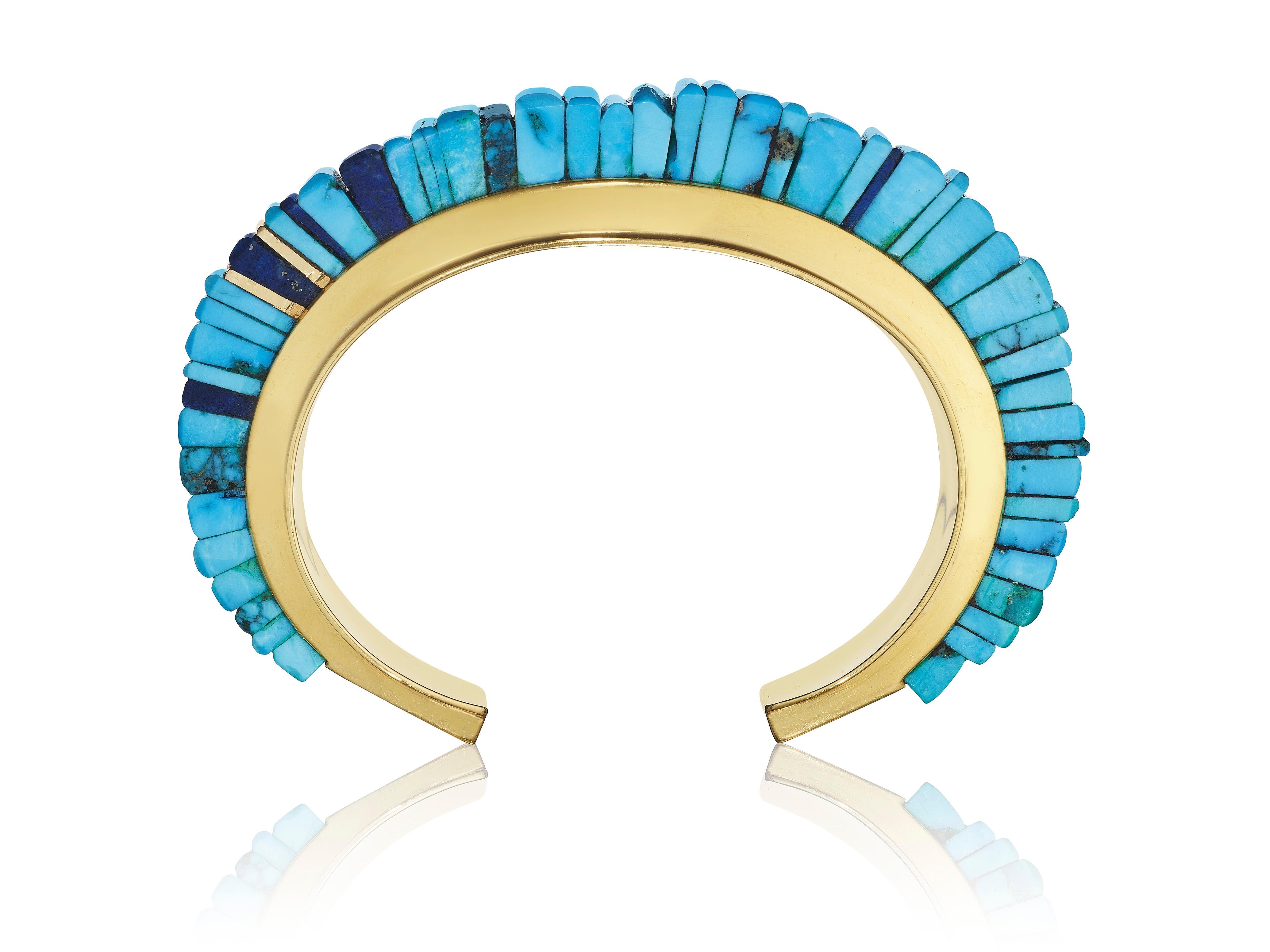 A bracelet composed of stacked turquoise segments of varying widths set atop the cuff, mixed with 4 lapis lazuli segments and two yellow gold segments; mounted in 18-karat yellow gold 
• Signed Loloma
• Measurements: 3 1/4 x 2 1/2 x ¾