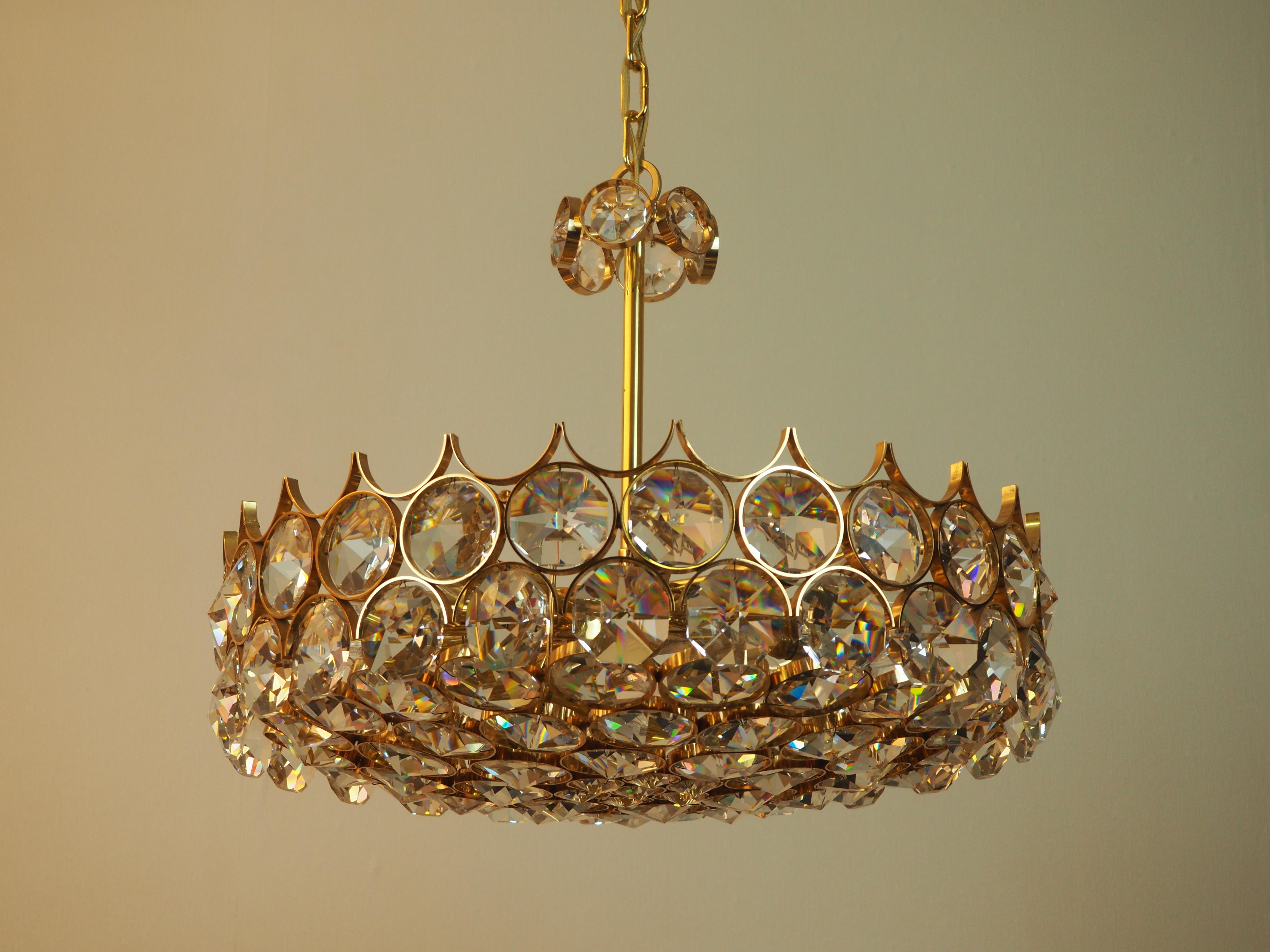 A wonderful midcentury gilt brass and crystal chandelier by Palwa, Germany, circa 1970s.
A highest quality light fixture made of 24-karat gilt brass and big a Swarovski crystal pieces.
The chandelier needs 11 x e14 (Edison) standard screw bulbs to