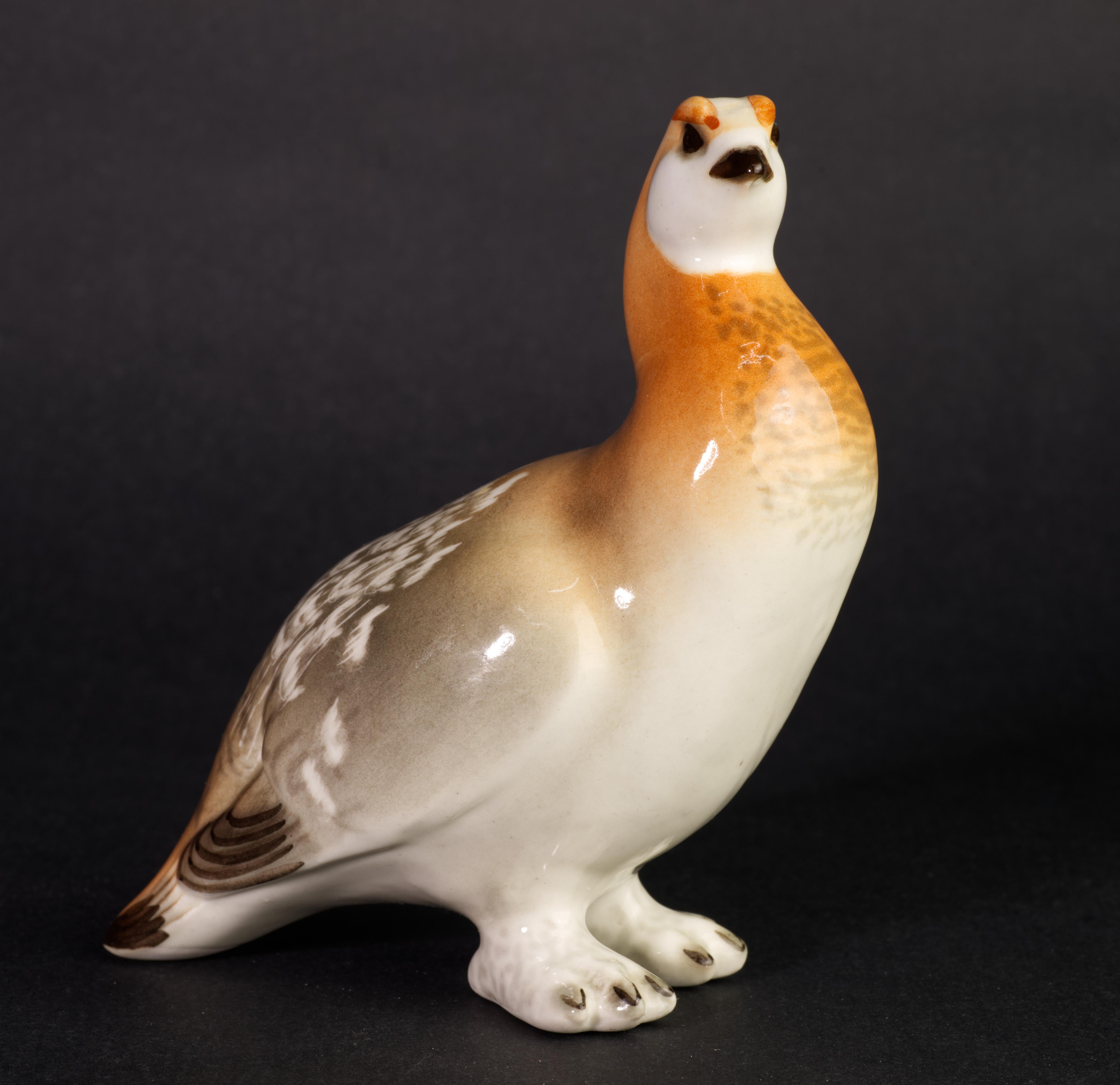  Charming standing grouse bird figurine is made of porcelain. Highly detailed hand-painted decoration in organic brown and beige palette complements complex, realistic shape of the piece.

The piece is signed with manufacturer's logo and Made in