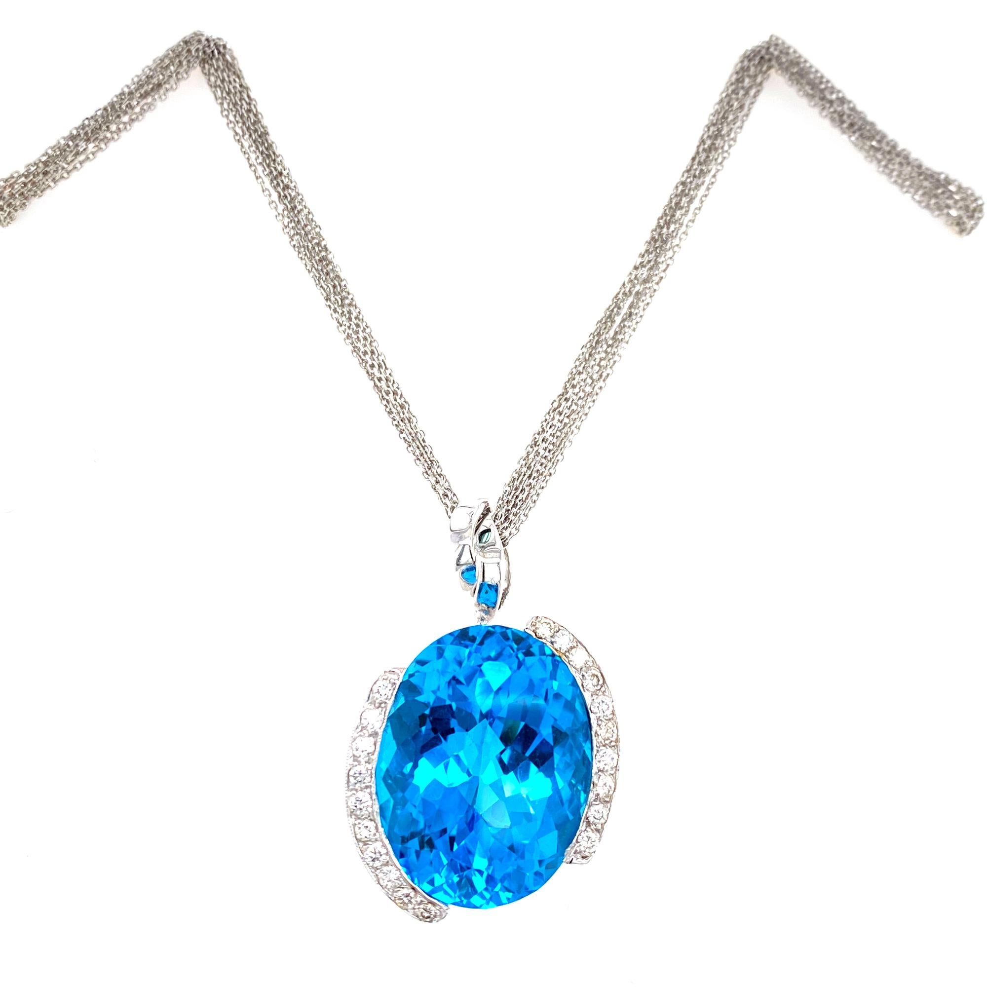 Gorgeous London Blue Topaz Diamond Pendant Necklace. The 30 carat oval cut blue topaz is set in a contemporary 18 karat white gold mounting featuring .50 carat total weight of round brilliant cut diamonds. The pendant measures 1 x 1 inches, and