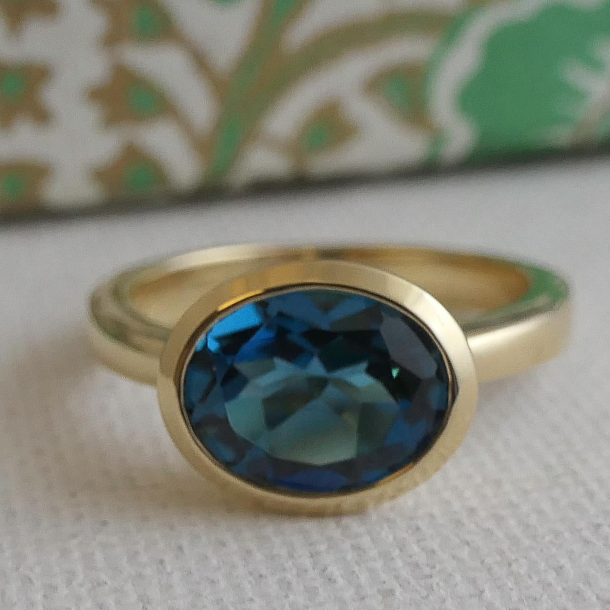 8x10mm London Blue Topaz is bezel set in 14kt yellow gold.

Ring Size is 7
