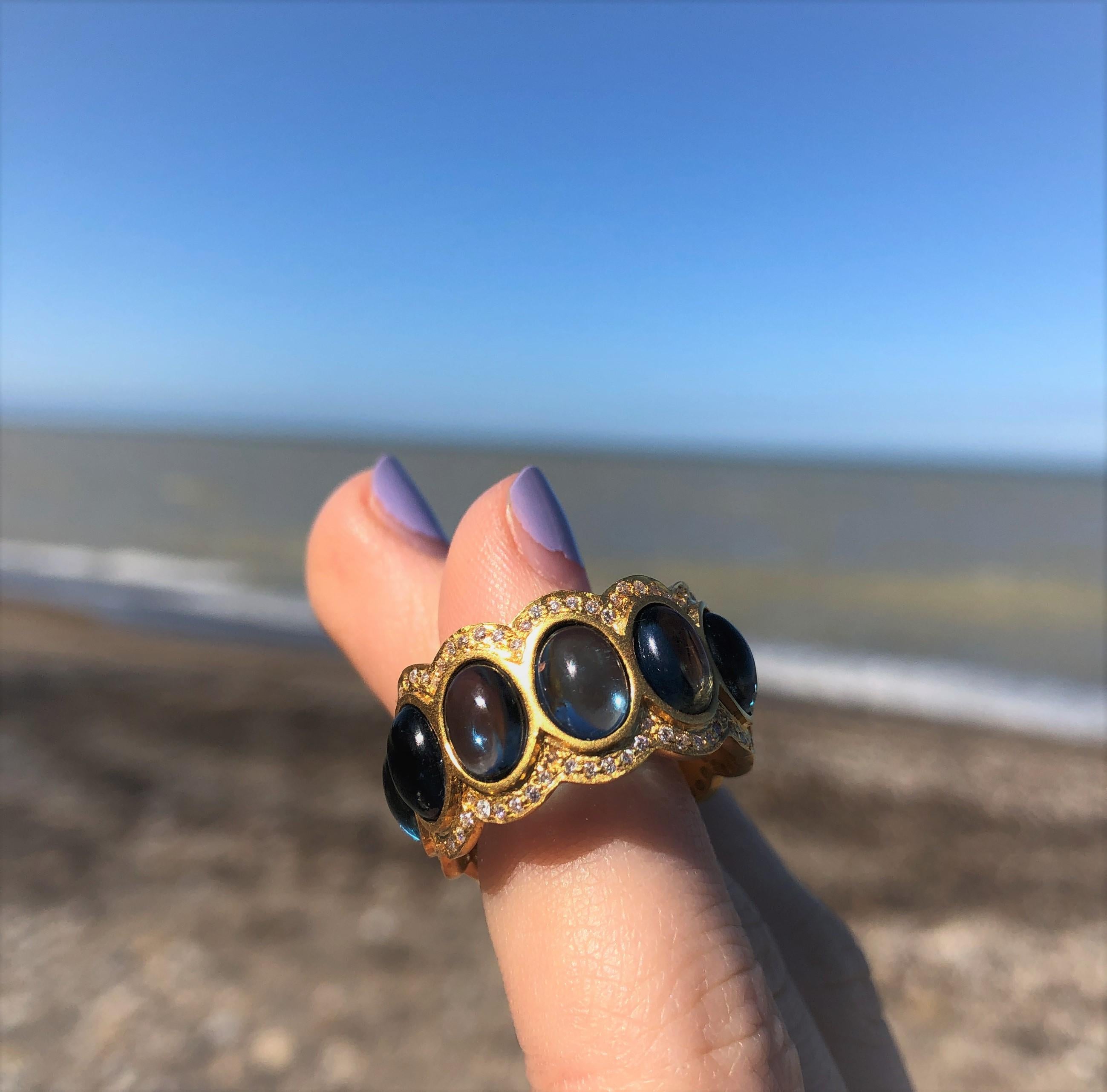 Designed by award winning jewelry designer, Lauren Harper, this eternity band glows with beautiful cabachon London Blue Topaz ovals, surrounded by diamonds and 18kt Gold. Comfortable on the finger, and a great finishing touch to every outfit. Size