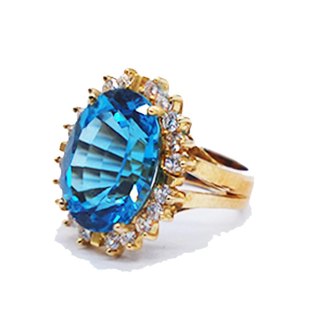 10 carat Blue Topaz, 1 carat Diamond Halo Ring set in 18 Karat Yellow Gold. 
The size of the ring is 21 x 18 mm wide.

The ring consists of an oval shaped dynamic colored Blue Topaz with beautiful sparkling faceting at sparkles 
Blue Topaz
15.76 x