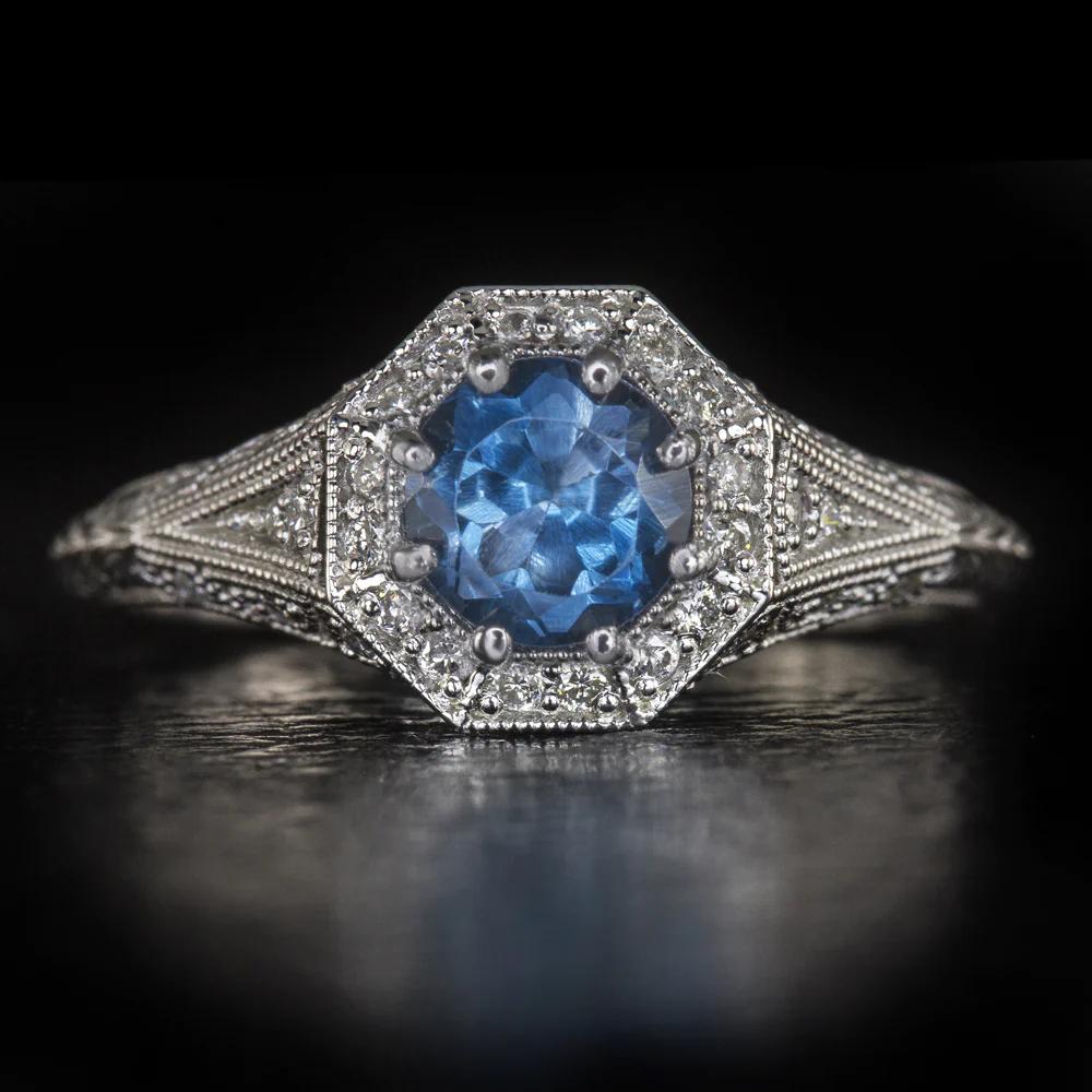 Featuring a bright London blue topaz circled by a halo of glittering diamonds.
This ring is beautifully crafted with romantic, vintage style details.
The main stone is a 0.50 Carat topaz with bright blue color and a lively play of light.
The ring