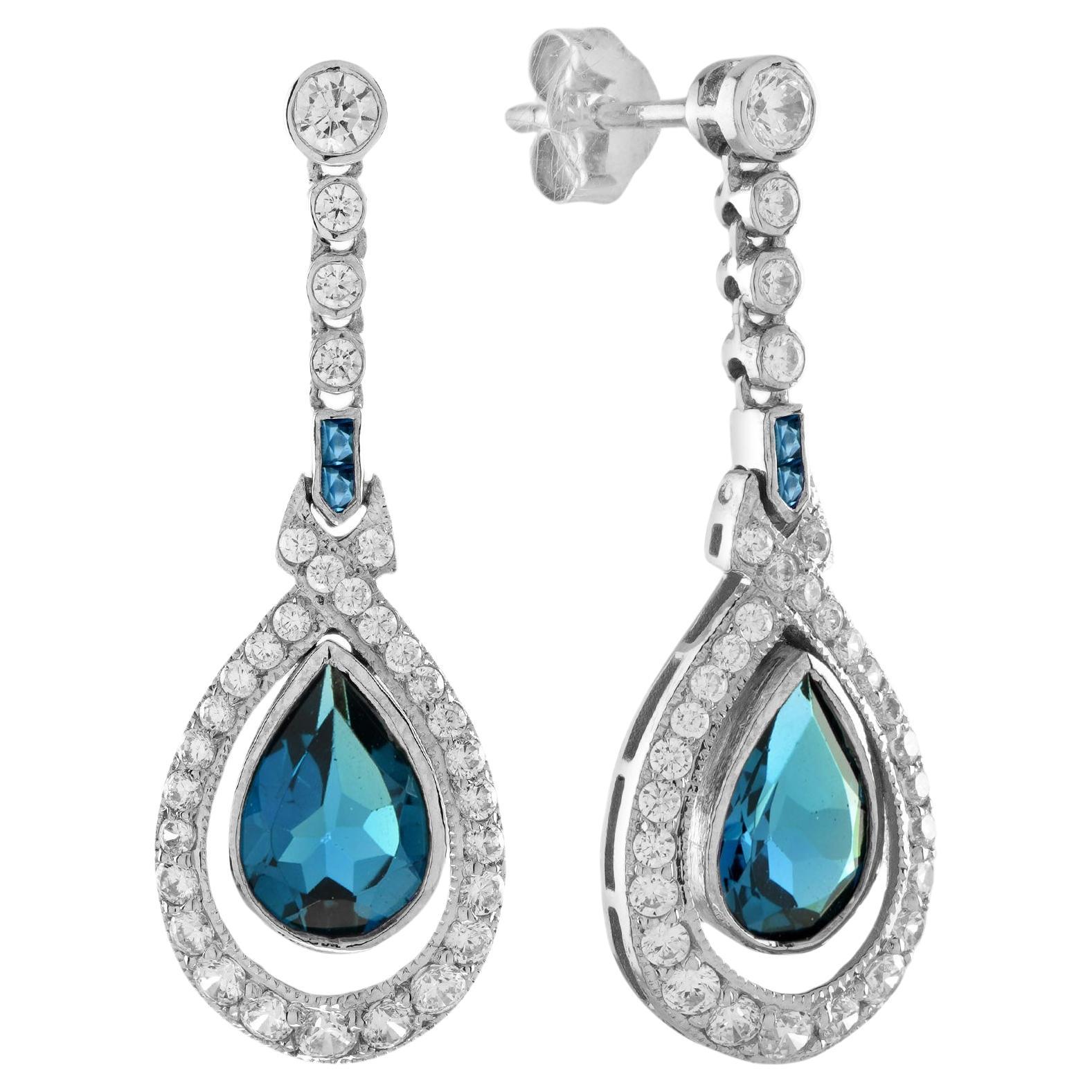 ANTIQUES OF LONDON - Boucles d'oreilles pendantes en or blanc 18 carats avec topaze bleue et diamant de style antique