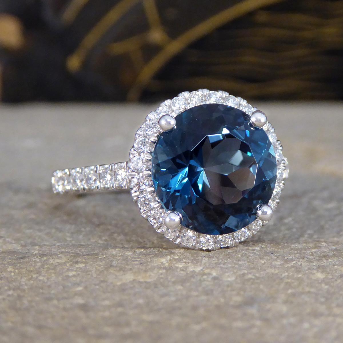 Introducing the captivating and mesmerising colour of the London Blue Topaz in a beautiful cluster ring design. This exquisite ring features a stunning 4.59ct London Blue Topaz at its heart, renowned for its deep and enchanting blue hue that echoes