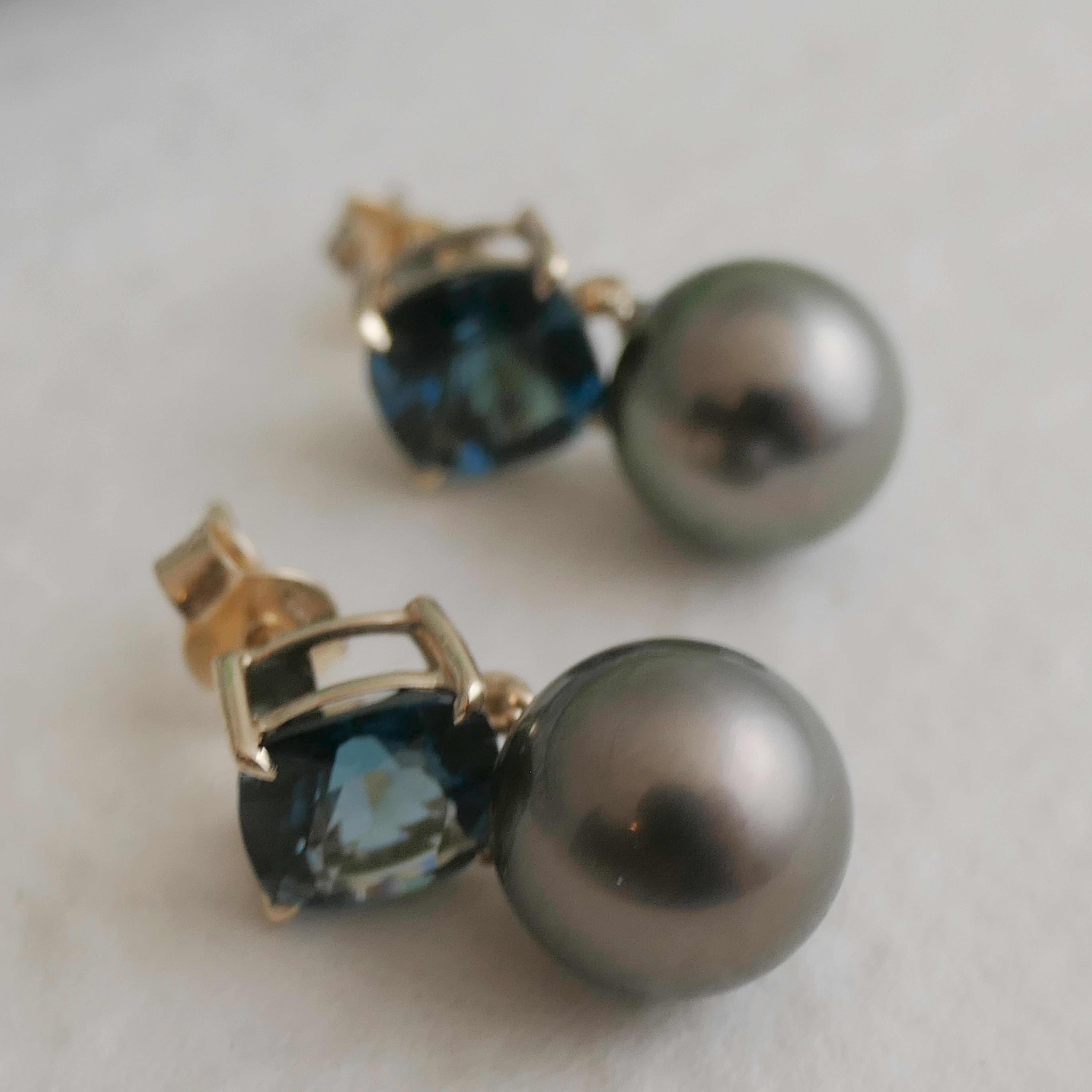 I topazi blu di Londra da 8 mm con taglio a cuscino sono incastonati in oro giallo 14 carati. Sotto il topazio sono incastonate perle nere tahitiane coltivate di colore naturale di 10 mm. La lunghezza è di circa 2 cm. Timbro 585 per l'oro 14kt.