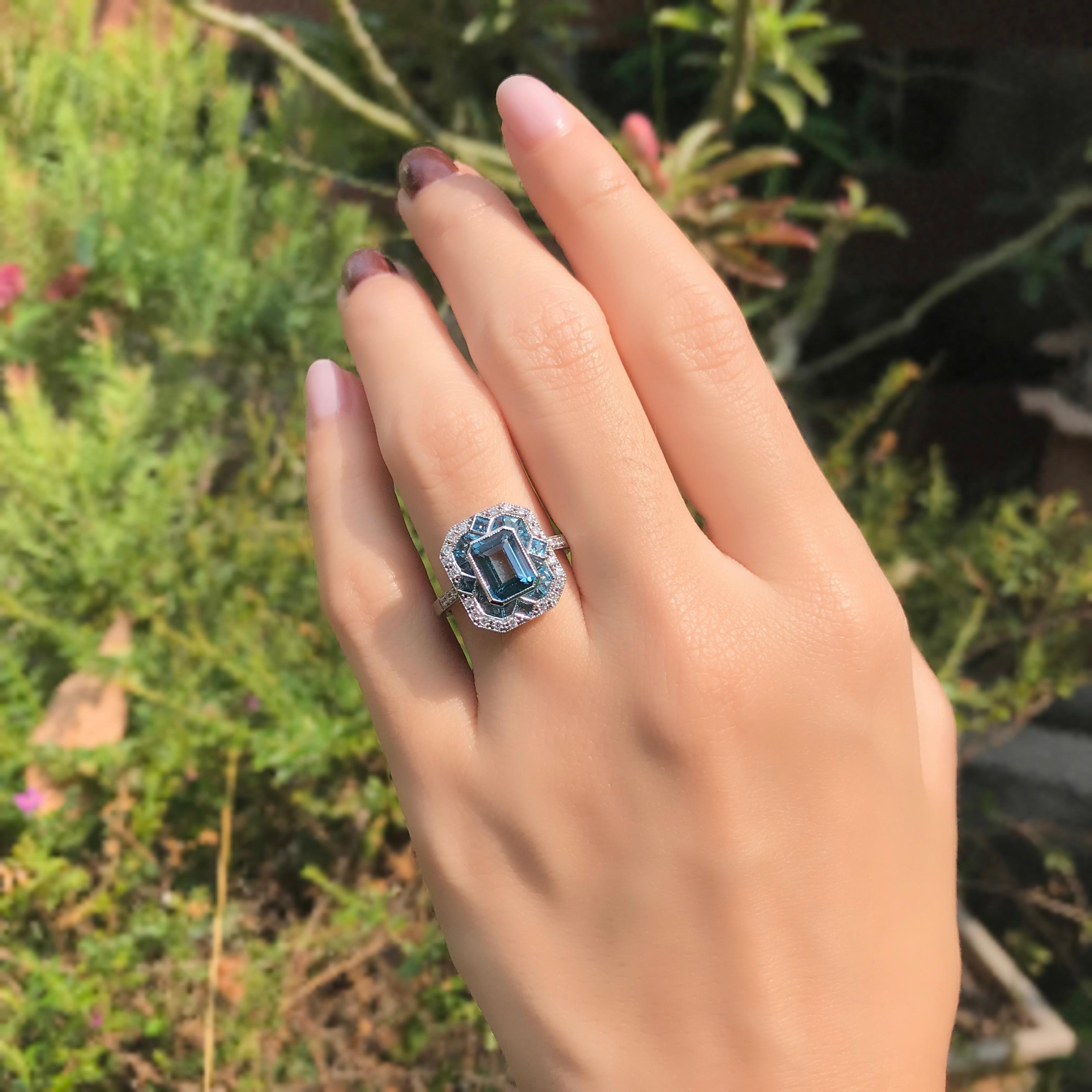 Fai una dichiarazione forte in blu. Questo anello in oro bianco 14k presenta un topazio blu di Londra dal taglio smeraldo perfettamente scintillante, incastonato in un ottagono. La pietra centrale è incorniciata da topazi taglio francese a nord,