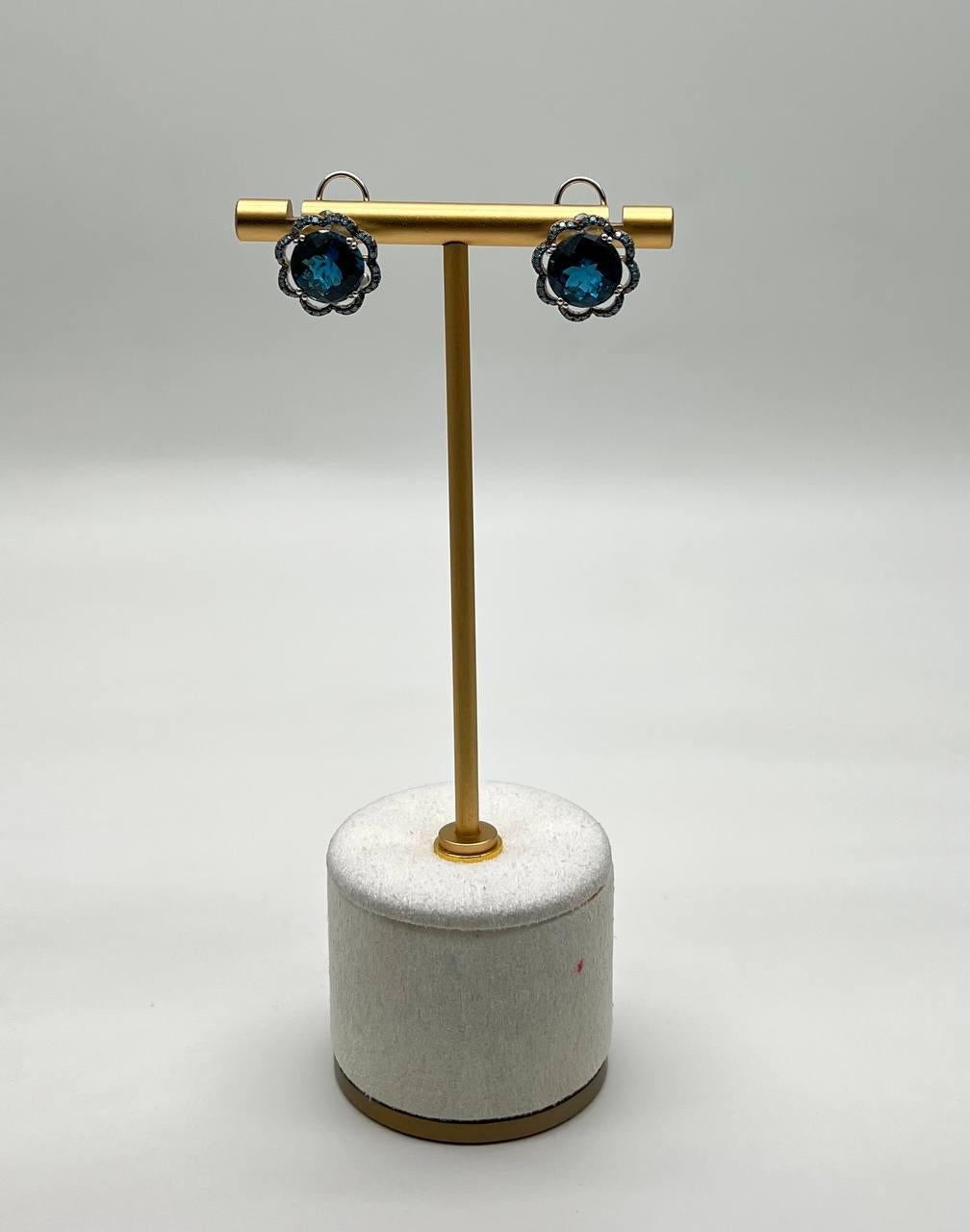 These sophisticated earrings features a striking blue London Blue Topaz set in a scalloped bezel.
The gemstones are surrounded by a delicate halo of smaller diamonds, enhancing their vibrant color.
14K White Gold.
0.40 CTW Diamonds
8.60 CTW London