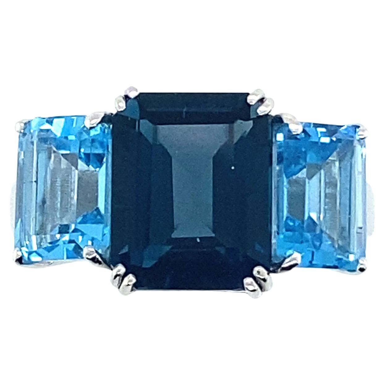 London Blue Topaz Emerald Cut Gold Ring.
Pretty art deco style ring in 18 carat white gold topped with a blue Topaz London centre stone and 2 Emerald Cut Blue Quartz stones. 

Weight: 5.41 grams gold 18 carats.
French size: 56
English size:P
US