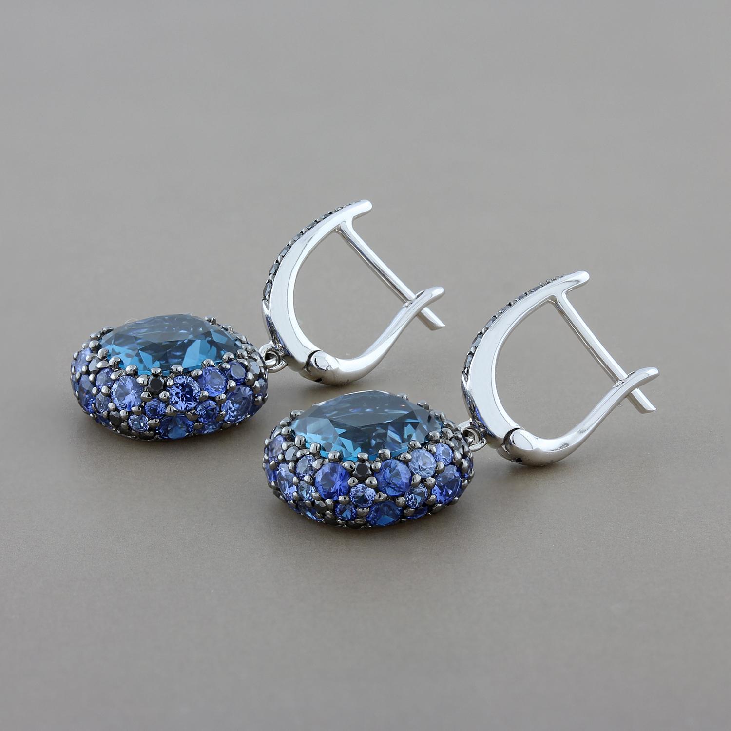 I’m blue! Feel beautiful in these drop earrings featuring 6.20 carats of London blue topaz surrounded by a cluster of 2.98 carats of sapphire and 0.50 carats of black diamonds. Set in 18K white gold, a lovely piece that can be worn every