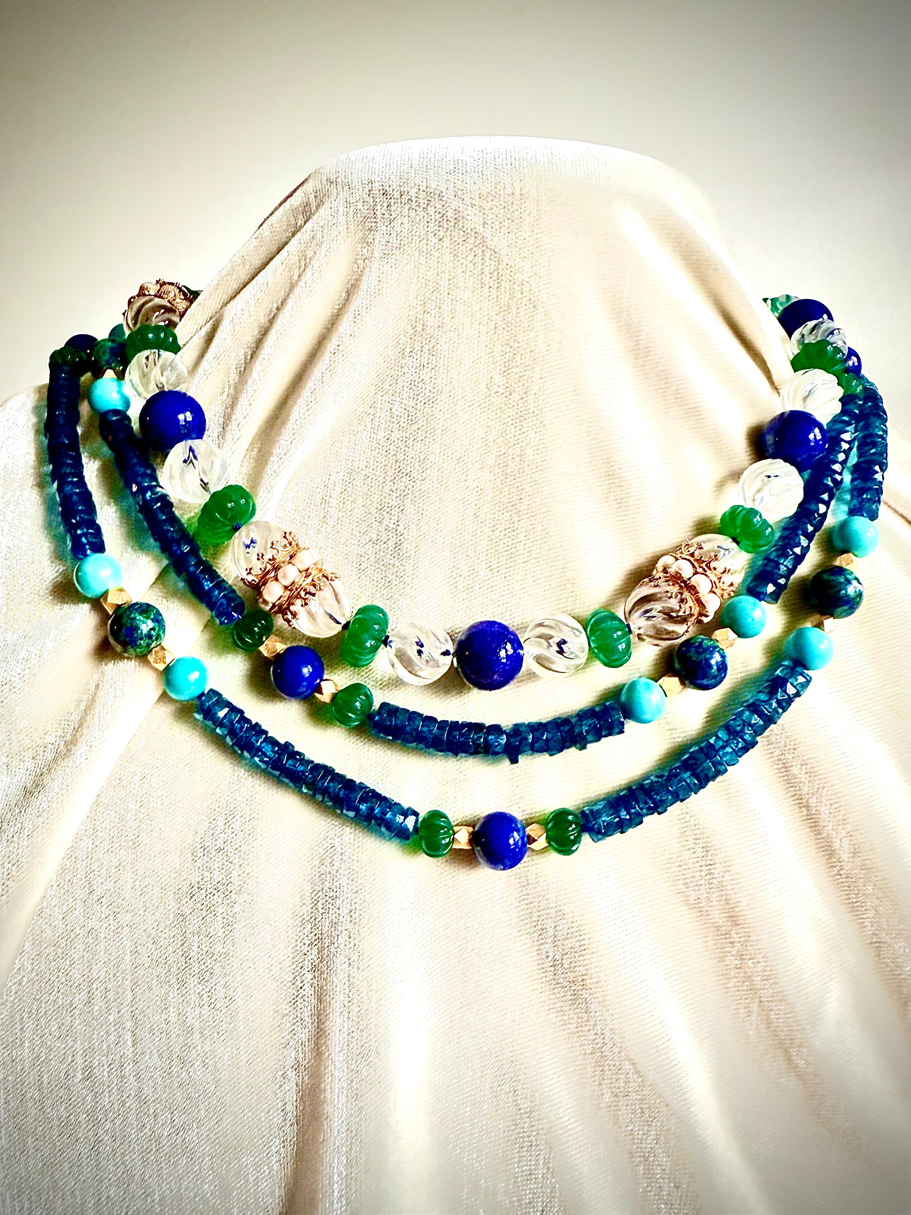 In mostra c'è una lunga collana di topazio blu di Londra sfaccettato con stazioni colorate di grandi perle rotonde lucide di lapislazzuli alternate a perle leggermente più grandi di azuremalachite. L'azuremalachite è una pietra bellissima e poco