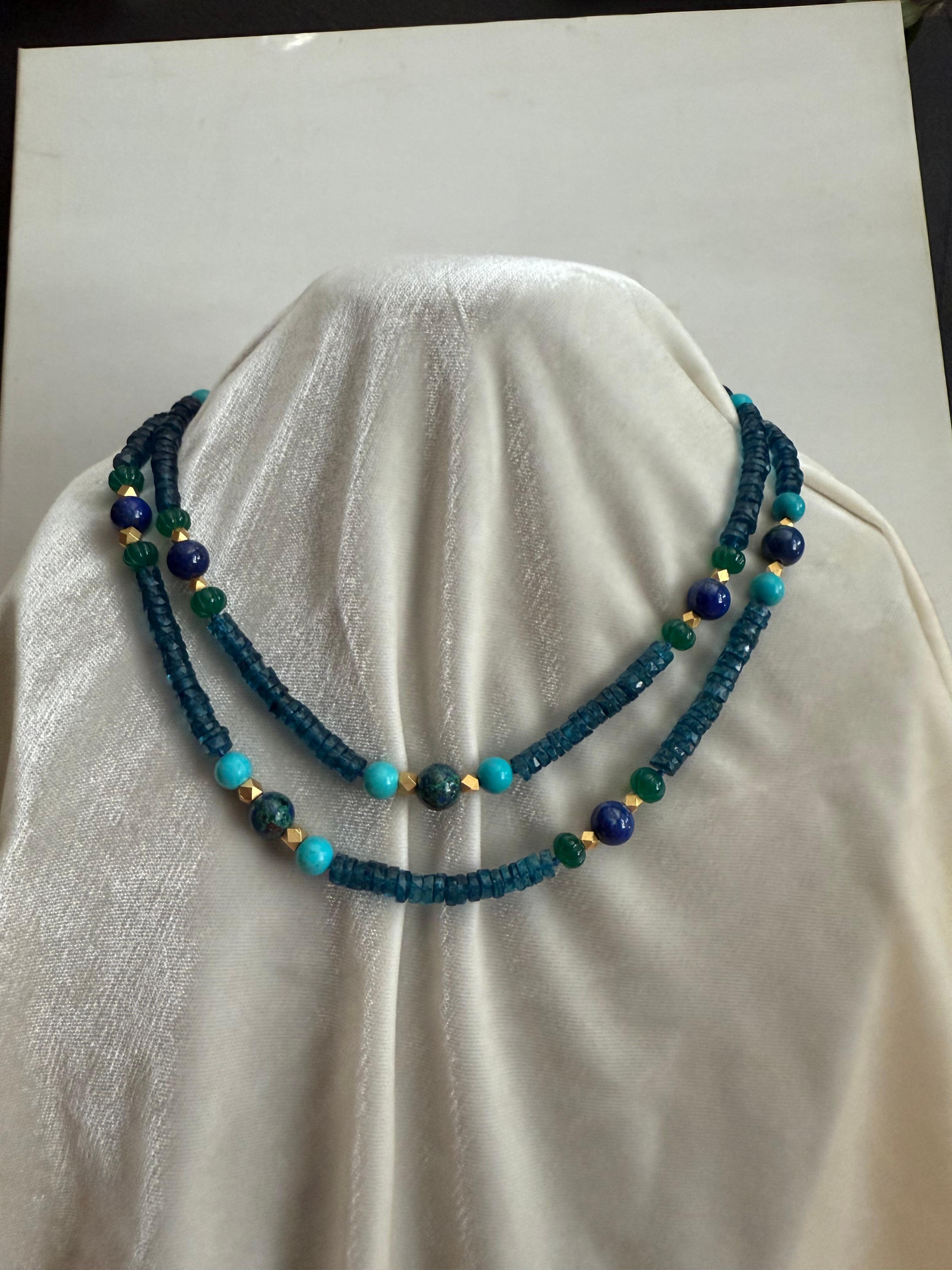 In mostra c'è una lunga collana di topazio blu di Londra sfaccettato con stazioni colorate di grandi perle rotonde lucide di lapislazzuli alternate a perle leggermente più grandi di azuremalachite. L'azuremalachite è una pietra bellissima e poco