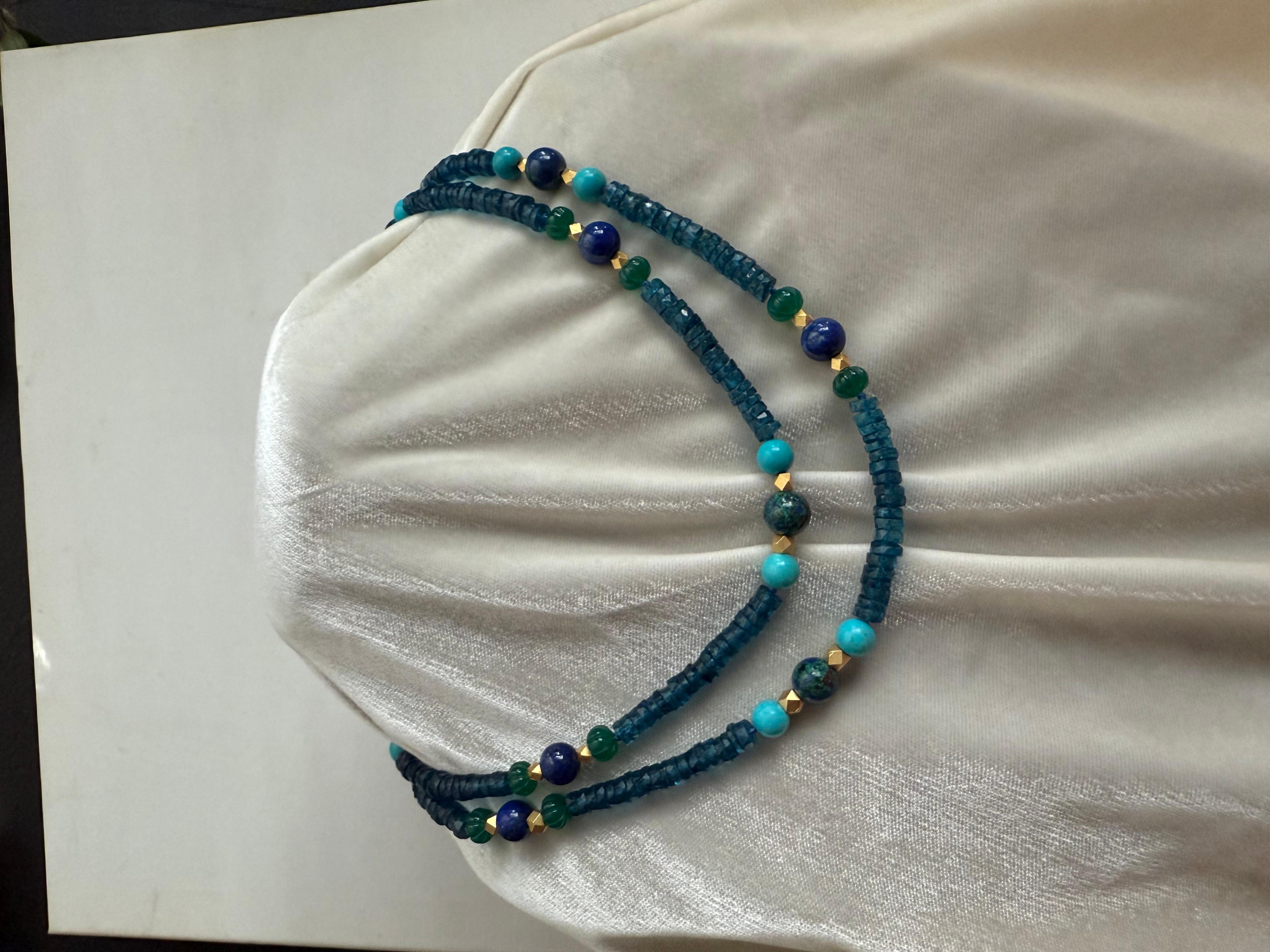 On view is a long necklace of faceted London blue topaz with colorful stations of large lapis lazuli round polished beads alternating with slightly larger azuremalachite beads. Azuremalachite is a beautiful and uncommon stone which is a naturally