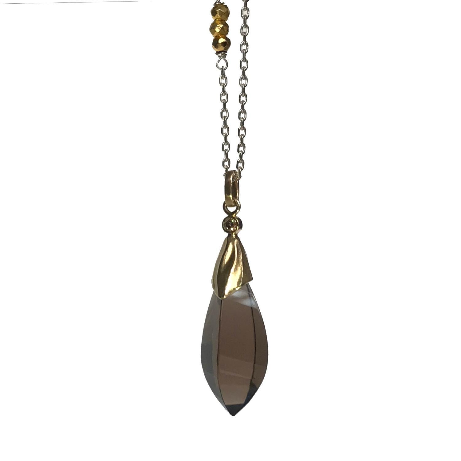 The smoky quartz pendant is handmade from  14 Karat Yellow Gold and features a faceted twisted 21.3 Carat Smokey Quartz accented with a 0.06 Carat Brown Diamond. 
The sterling silver chain is 30