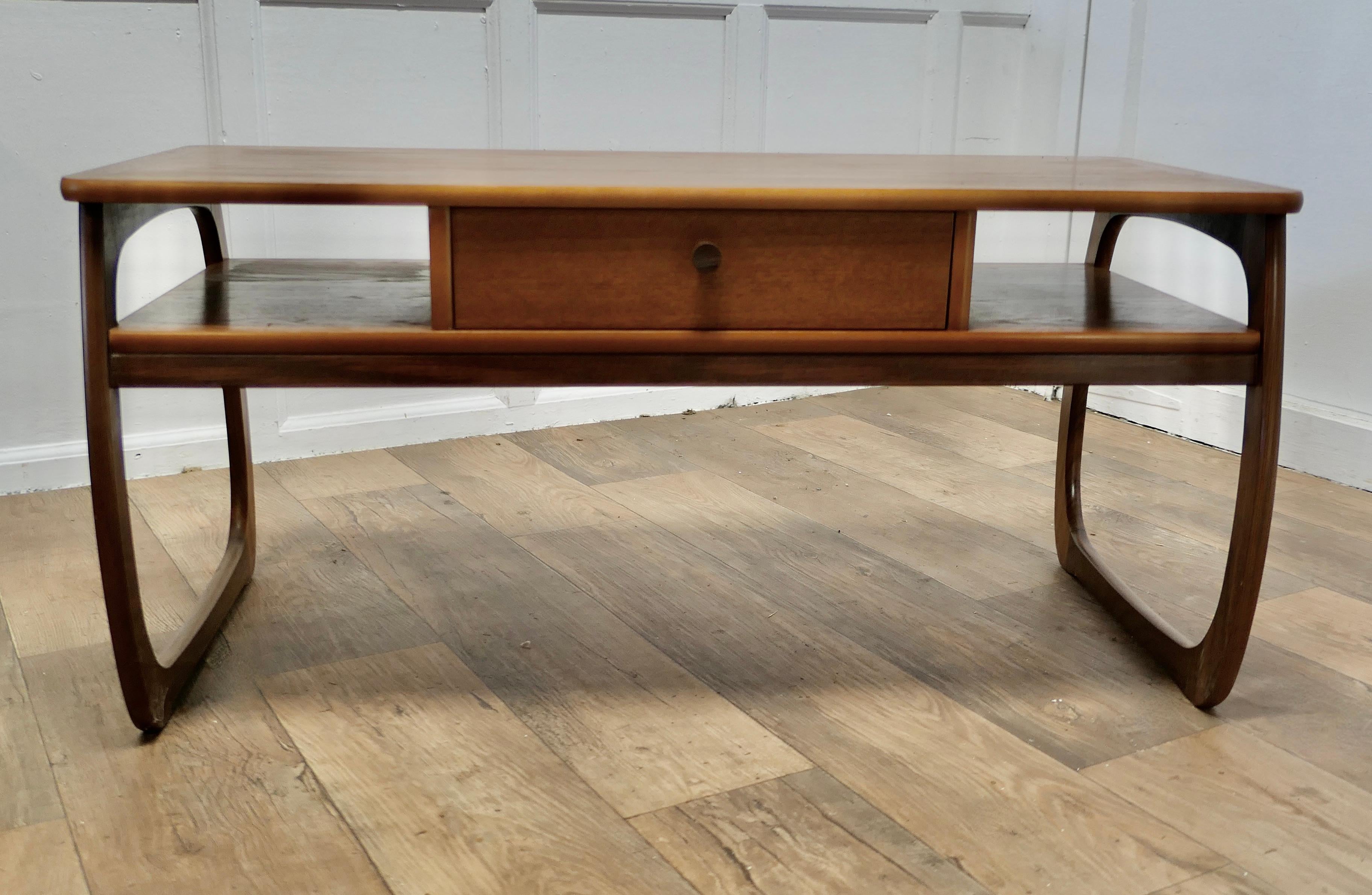 Long 1950s Parker Knoll Cube Shape Coffee Table

This is a good sturdy table, it has a very attractive Danish style double cube shape with bow sided legs
Beneath the rectangular top there is a central double sided drawer and magazine storage on