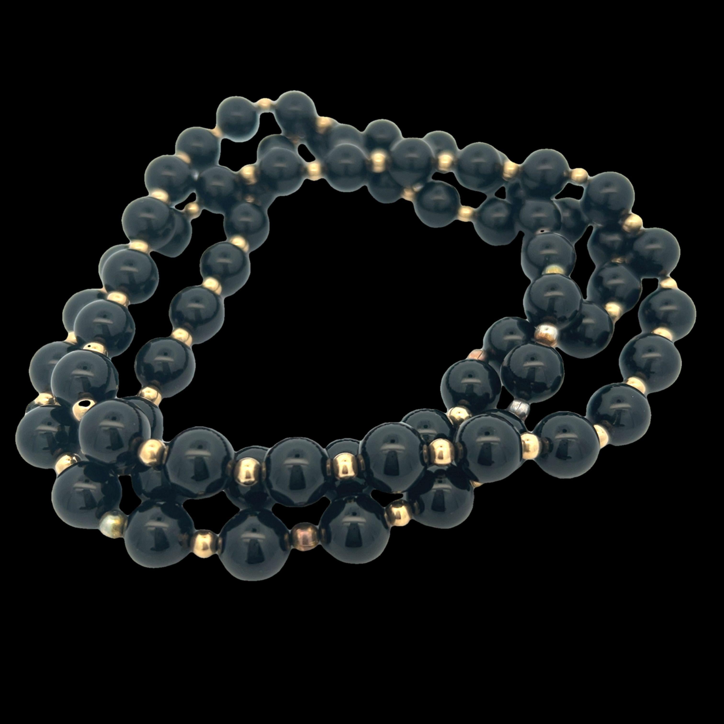 Questa deliziosa collana è realizzata con perline di onice nera da 10 mm e distanziatori in oro giallo da 14k. Questa collana misura 36 pollici di lunghezza e può essere indossata e acconciata in diversi modi. Sia le perle di onice nera che i