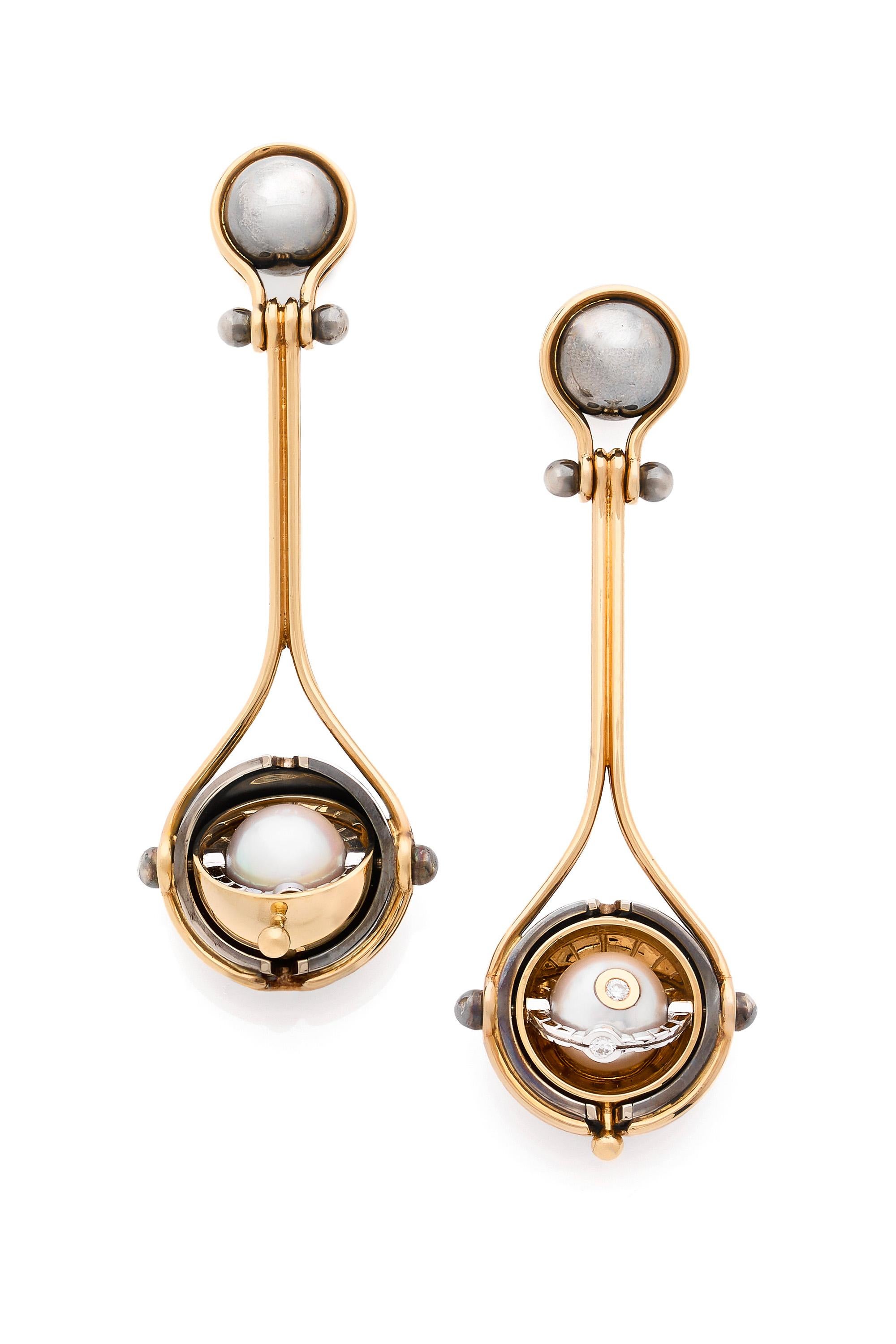 Gold and distressed silver earrings.  Rotating spheres revealing an Akoya pearl  encircled by a white gold ring set with diamonds.

Details: 
Akoya Pearls 
Diamonds: 0.06 cts
18k Yellow Gold: 14 g
Distressed Silver: 5 g
Made in France