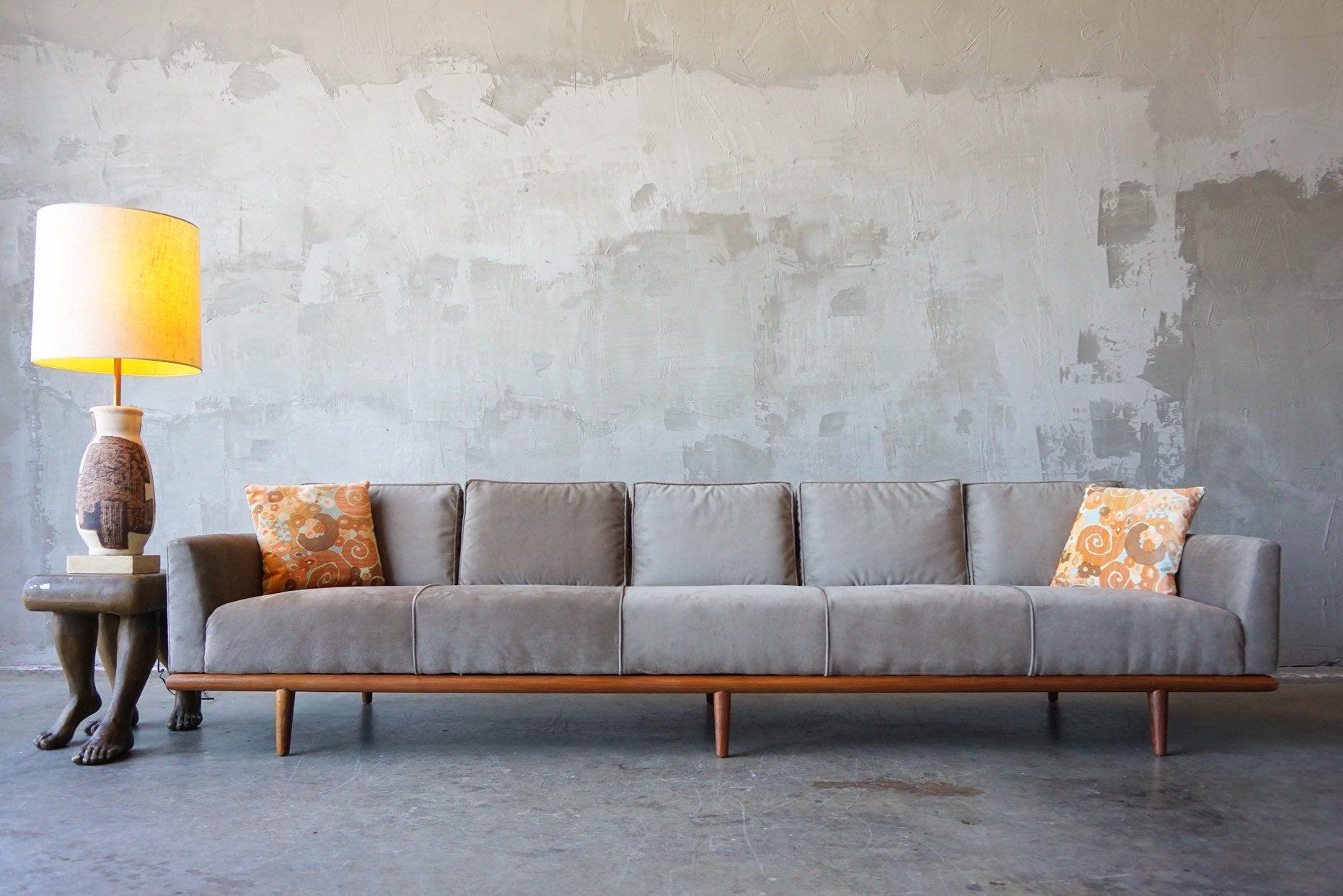 Beautifully designed long and low sofa attributed to Maurice Bailey for Monteverdi Yound, circa 1960s. 

Featuring a solid walnut base and covered in a warm grey/taupe velvet. 

Excellent condition, as photographed. Recently refinished base and