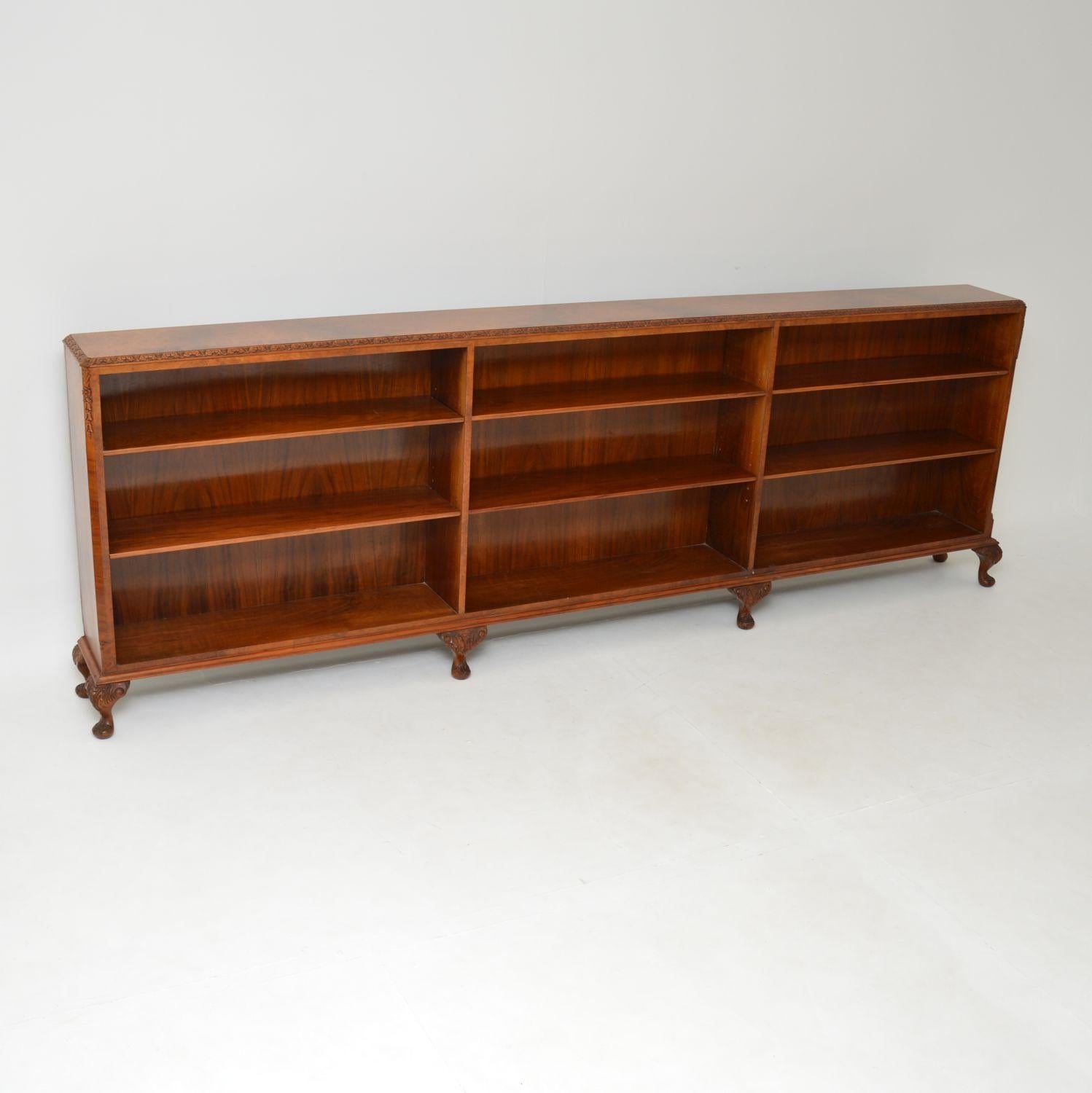A very long and impressive antique open bookcase in burr walnut. This was made in England, it is in the Queen Anne style and dates from around the 1930’s.

The quality is superb, with fine and crisp carving on the cabriole legs, all along the top