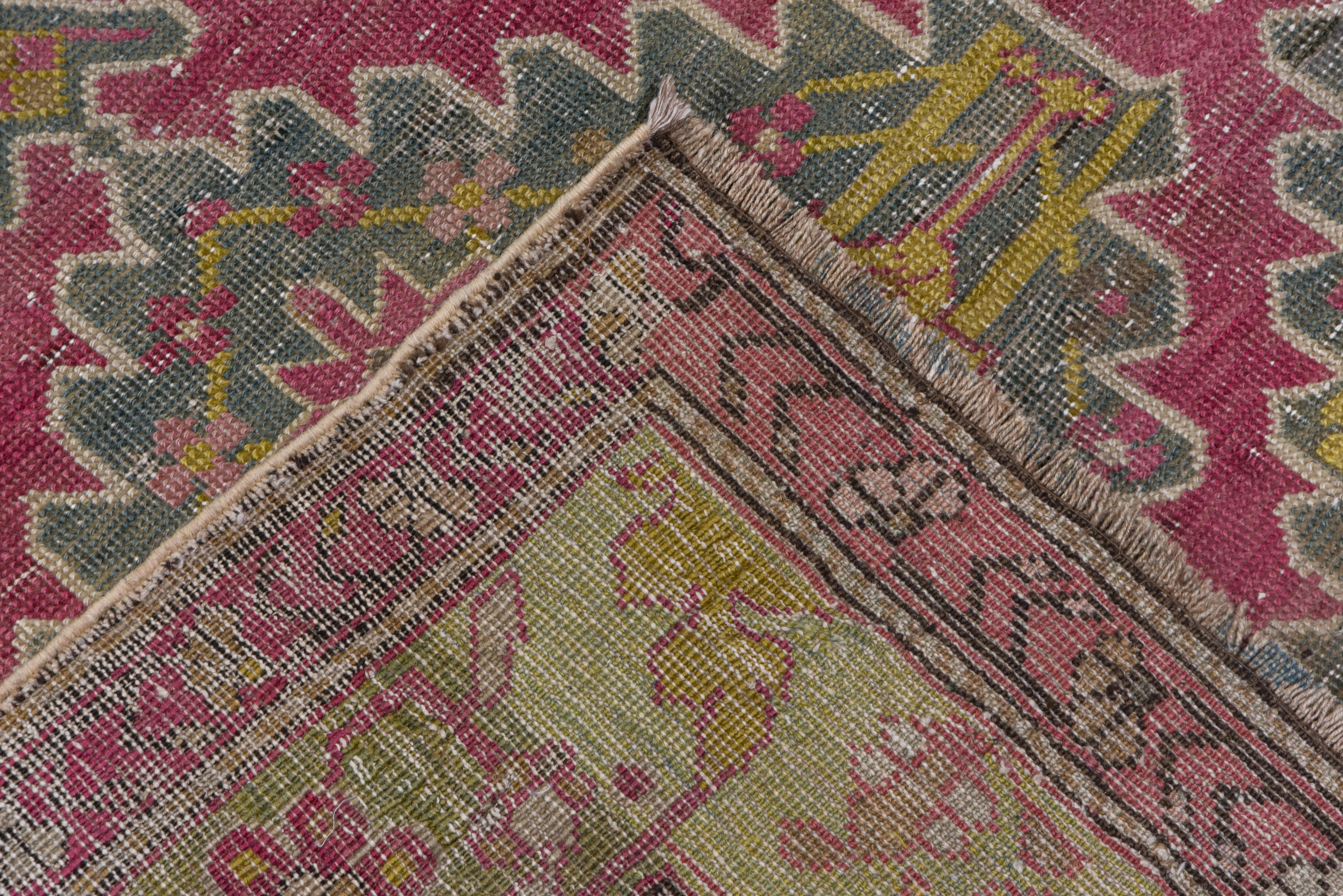 This runner has a cochineal red field that features nine notched lozenges joined into a central long pole medallion, all with cruciform centers and en suite side filler triangles, in the so-called 