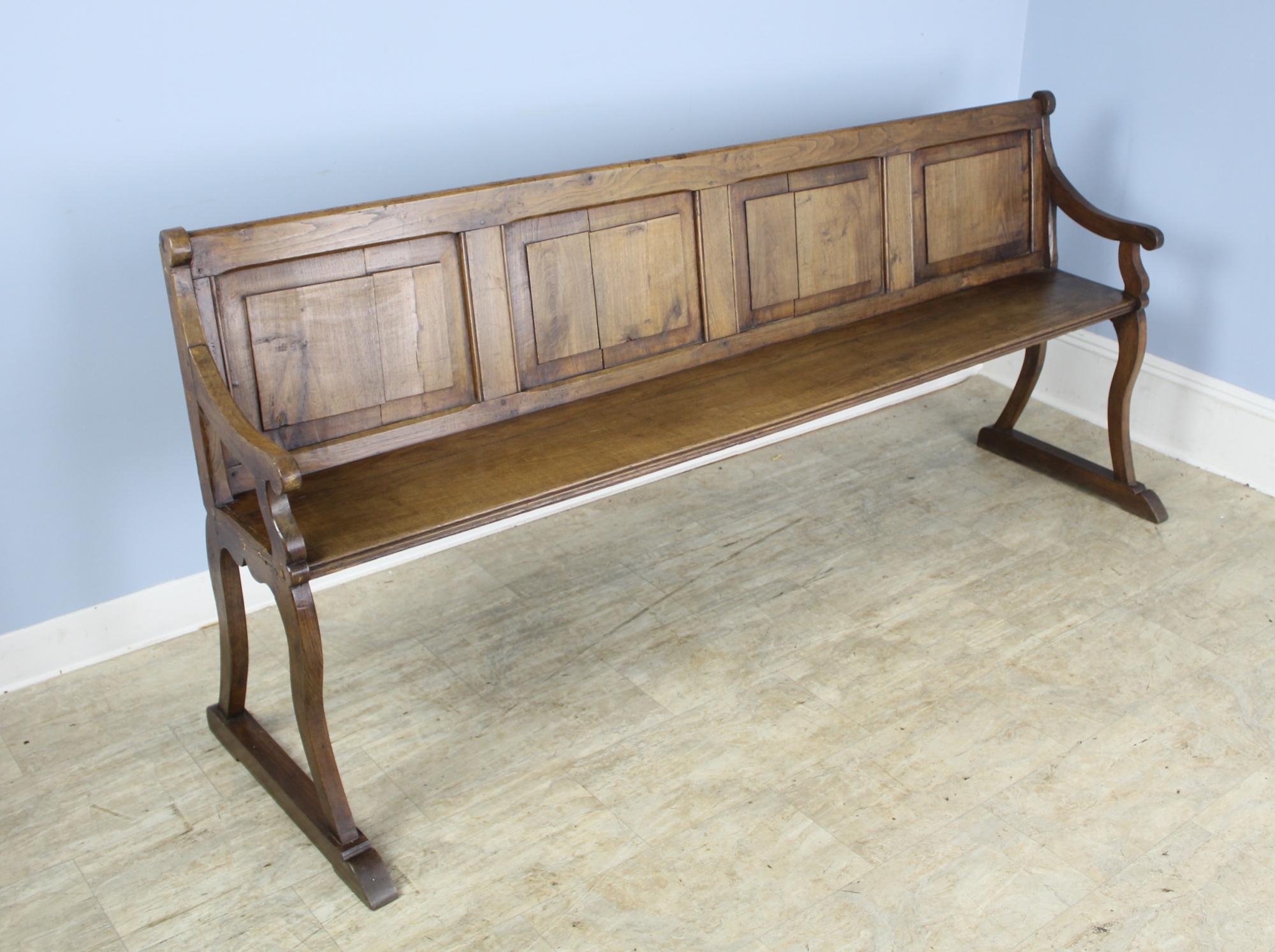 Slim and elegant, this bench is very much in the Victorian style. The color and patina of the chestnut are lovely and the seat height is a comfortable 18.5 inches. Good inset panels on both the front and back. Would be right in the front hall or