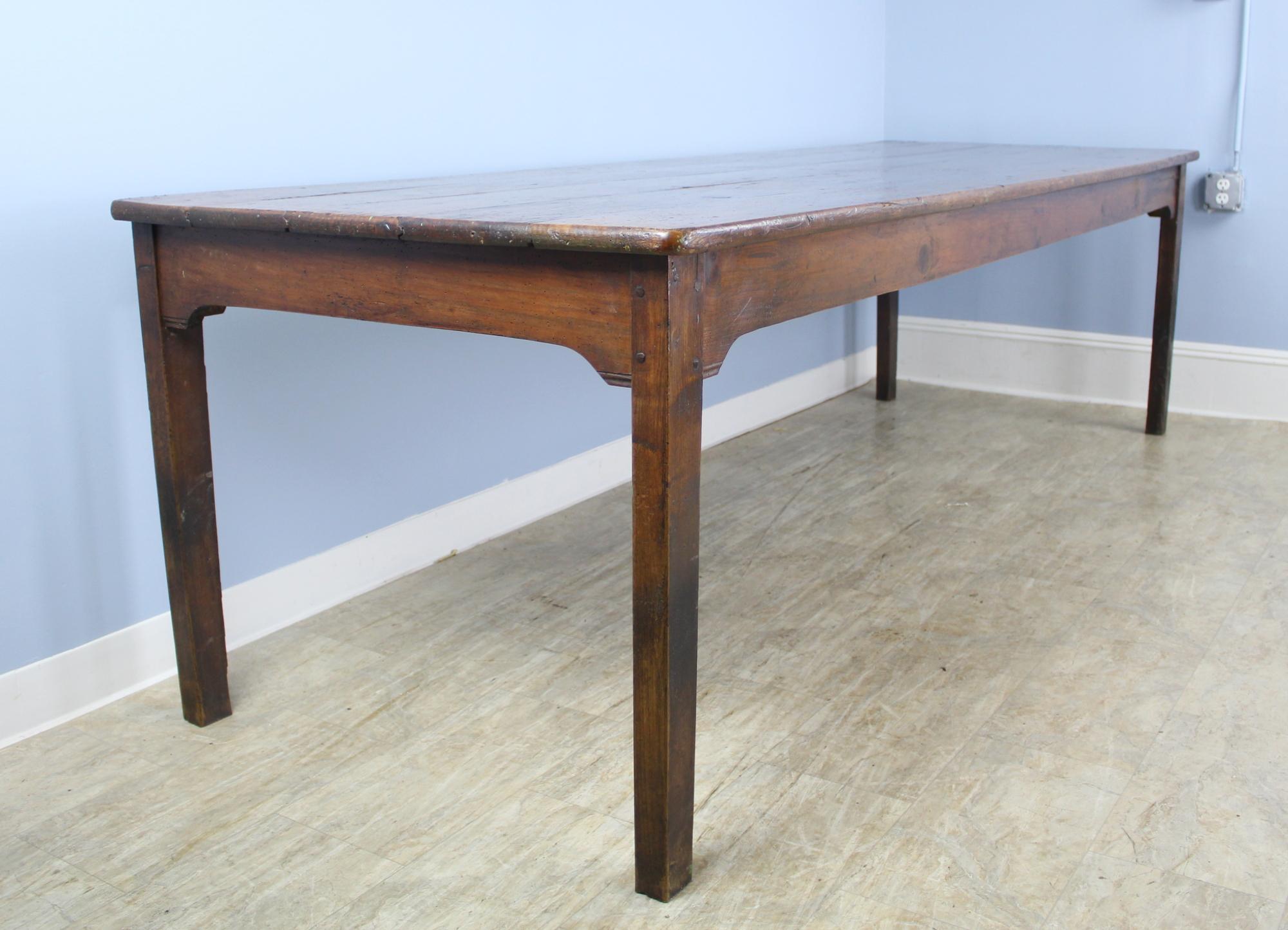 A long rustic pine farm table with glorious pine grain and natural knot holes. The color and patina on this piece are really good. With 97.5 inches between the legs on the long side, this table can seat ten comfortably. The apron height of 24.75