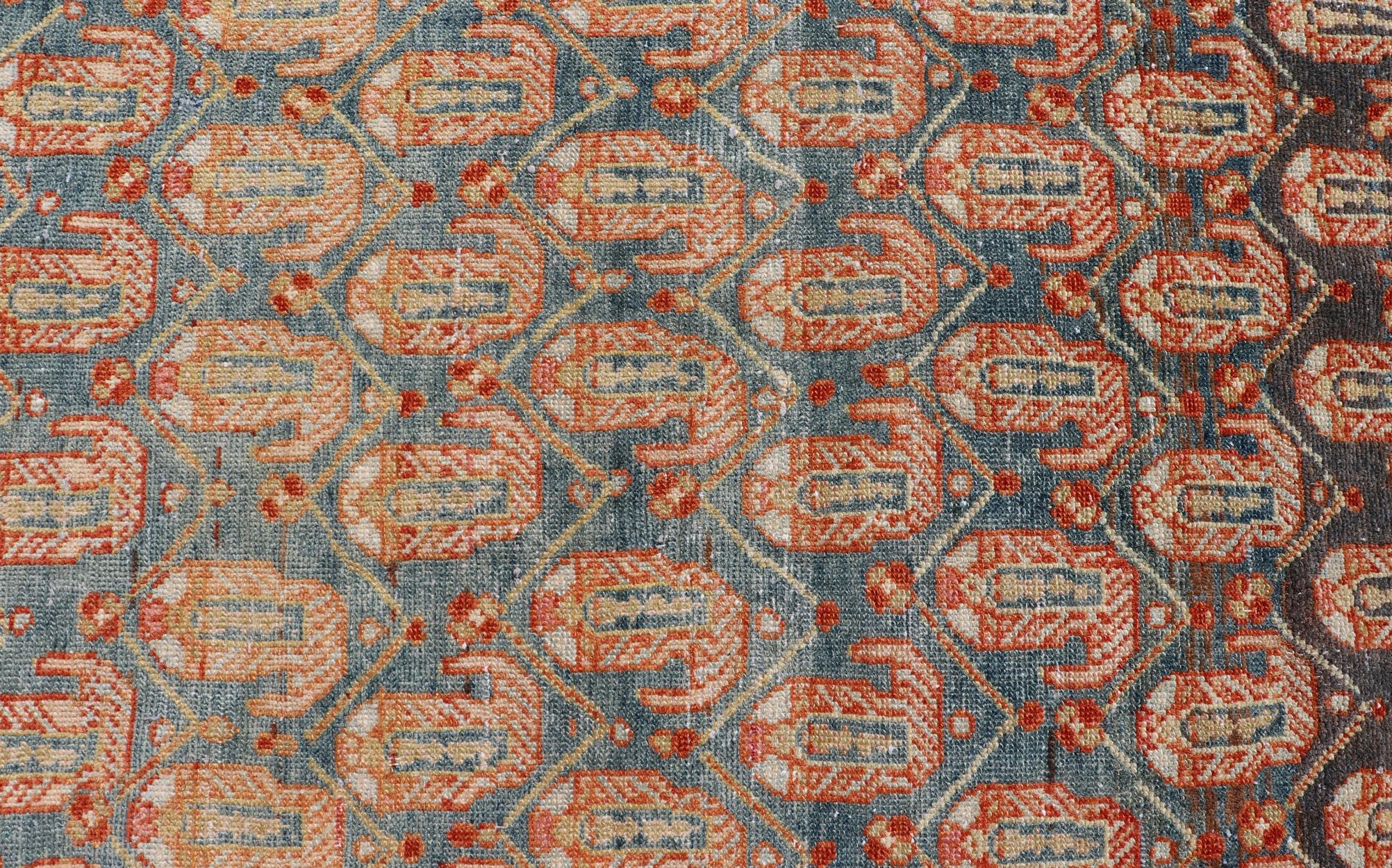 This long antique Persian Malayer runner has been hand-knotted in wool and features an all-over sub-geometric design rendered in multicolor. A complementary, multi-tiered border encompasses the entirety of the piece; making it a marvelous fit for a
