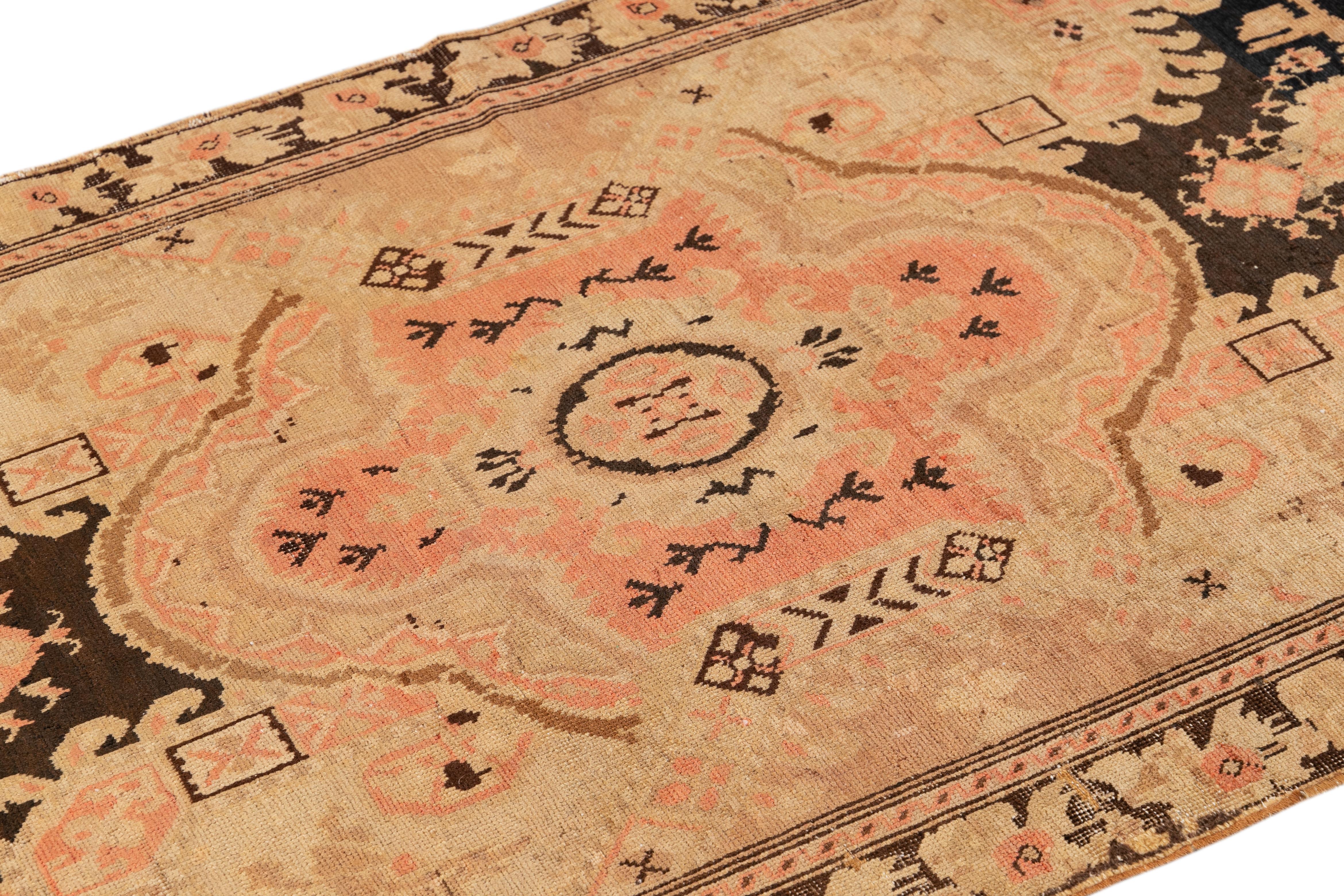 Beautiful antique Turkish Kurd hand-knotted runner with a beige color field. This piece has an all-over medallion floral design with peach, brown, and dark blue accents. 

This rug measures 3'6