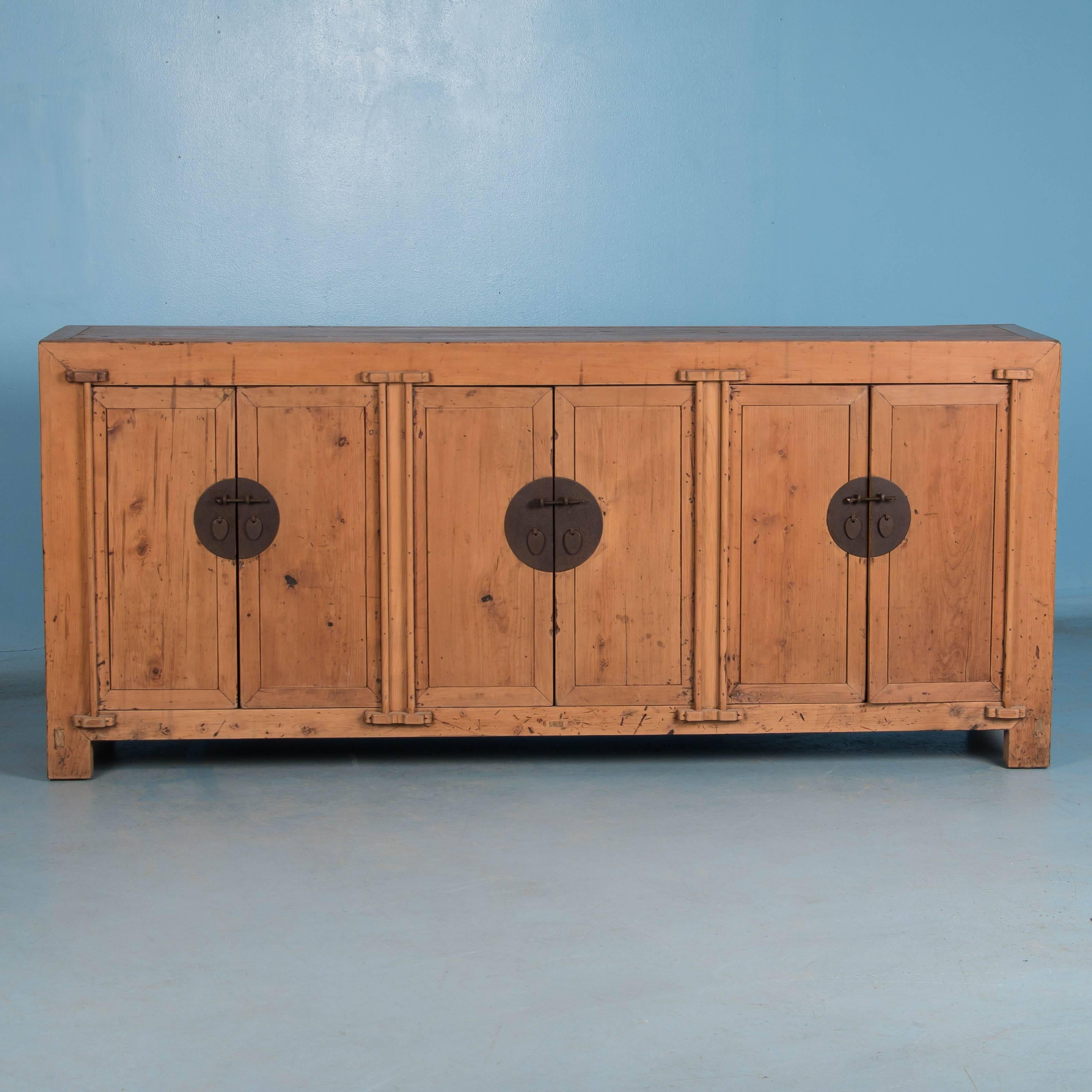 The clean lines and simplicity of this Chinese sideboard with it's unfinished wood, gives this piece a more country feel. The aged red lacquer on the inside of each of the six doors is an indication that this piece was originally lacquered all-over.