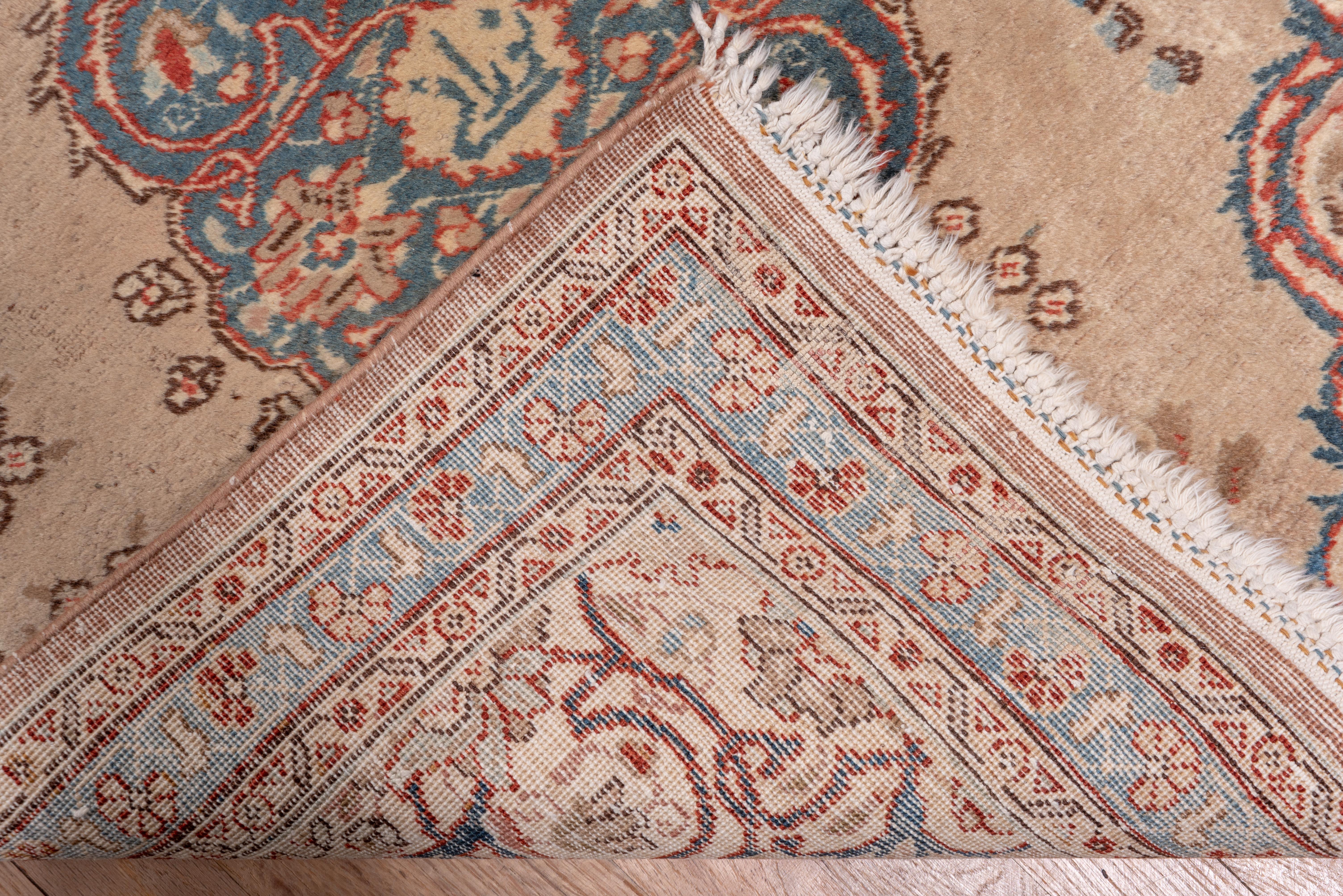 The light brown field features six-light blue floating cusped elliptical arabesque medallions with en suite ivory half medallions along the sides. Very narrow pale blue border with tilted fan palmettes. Well woven. Medium full pile, cotton