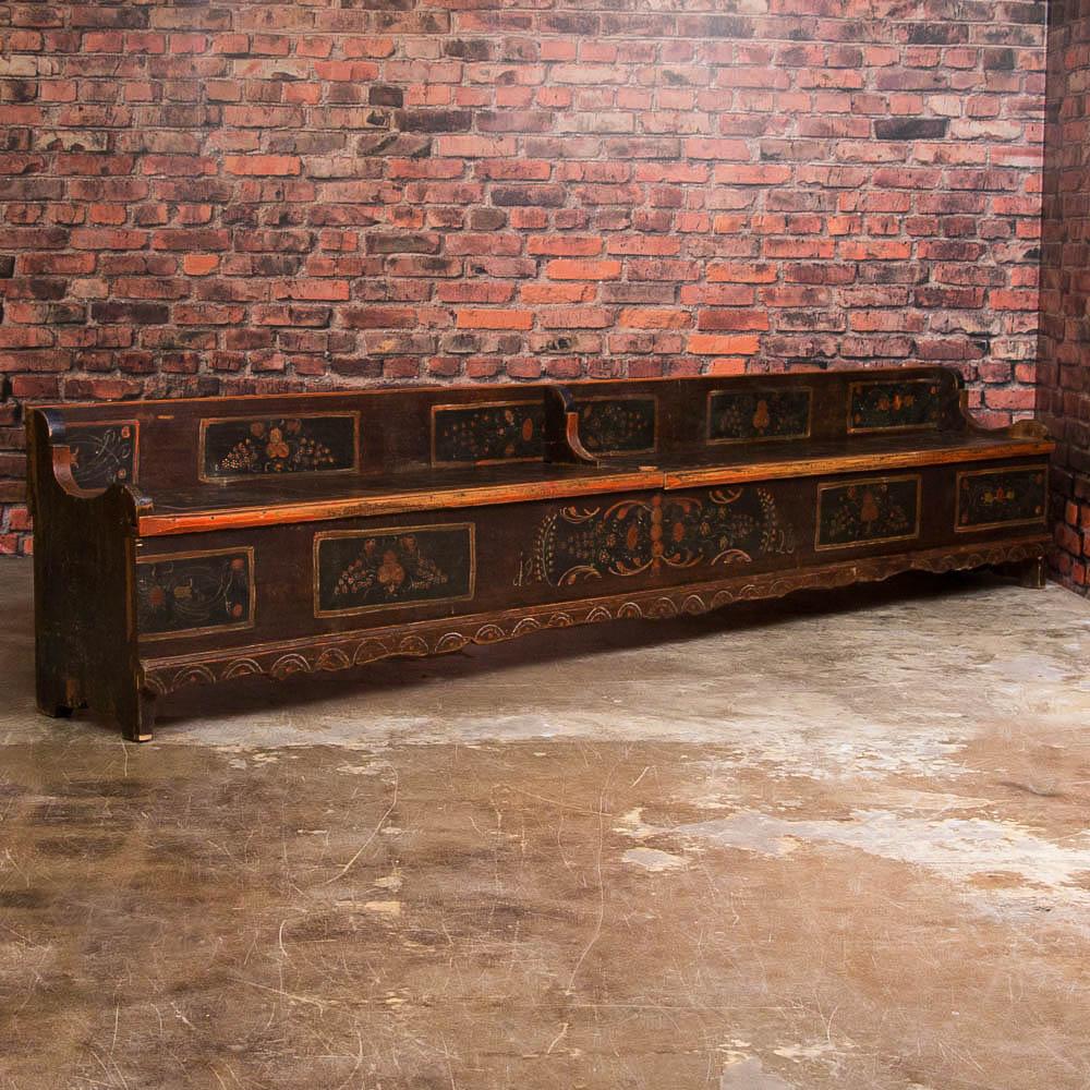 This long pine bench still maintains the traditional folk art paint of the late 1800s into the 1900s, with elaborate floral motifs that are often painted on dark blue and complementing eggplant colored backgrounds such as this one. Reflecting