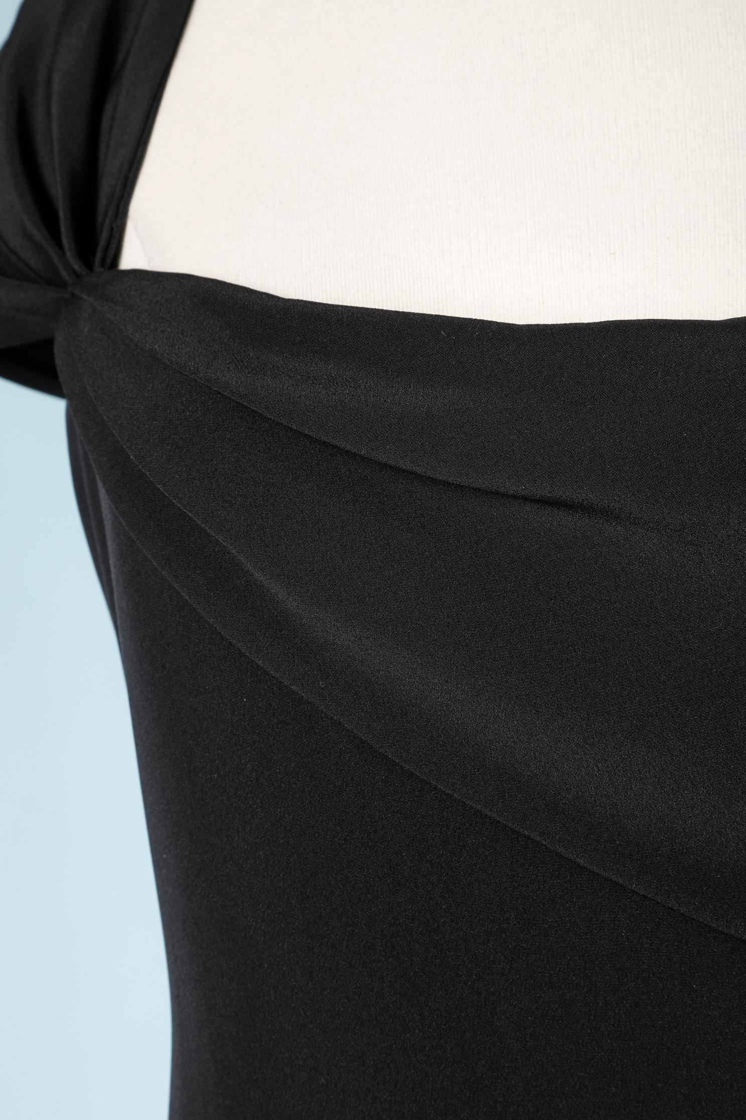 Longue robe asymétrique en crêpe noir drapée sur l'épaule droite. Fente au milieu du dos = 45 cm. Doublure en soie.
Fermeture éclair sur le côté droit.
Taille L