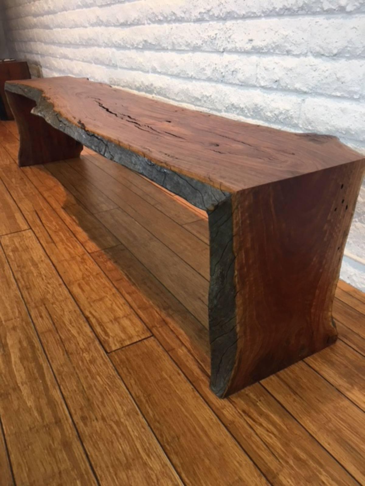 Eucalyptus wood long bench designed, produced and made by master wood artist and designer Scott Mills who only uses reclaimed (deadfall or storm downed trees) in the pieces he designs and produces. This piece is big, solid and eye-catching.
