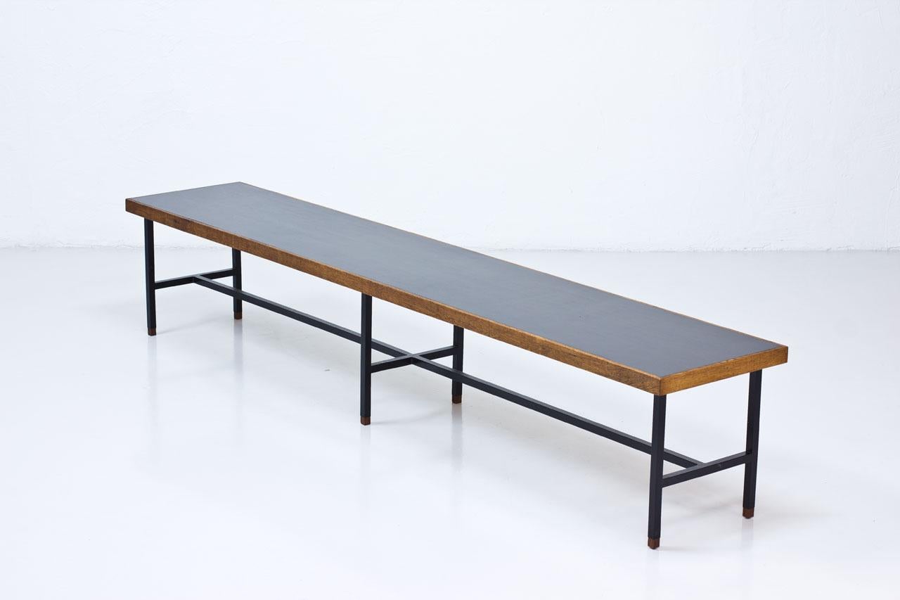 Rare long bench/ side table design attributed to Kurt Østervig for Jason Møbler. Manufactured in
Denmark during the 1950s. Black laminate top with oak frame, black lacquered steel base with teak foot enders.