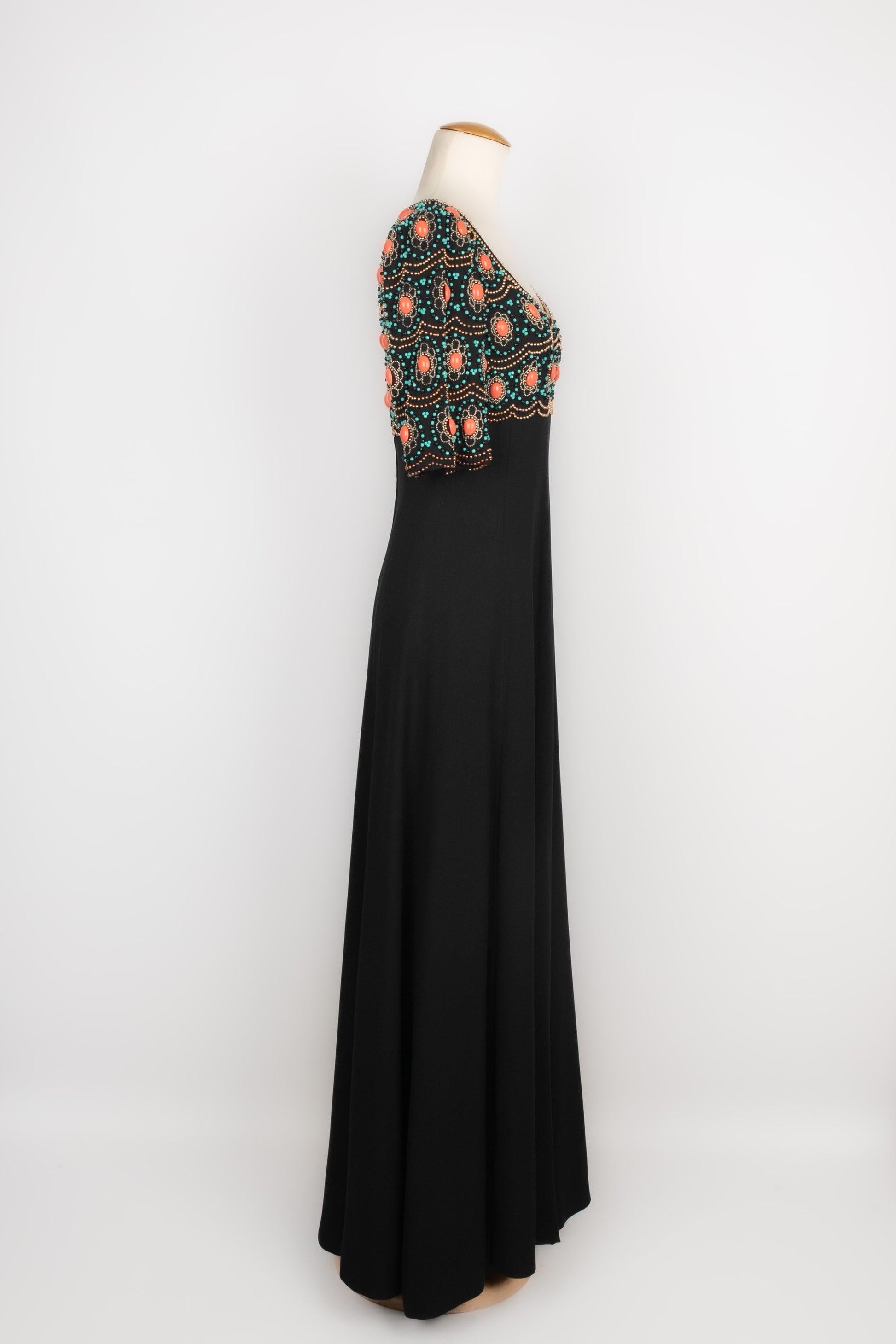 Longue robe en crêpe noir, corsage entièrement brodé de perles turquoises, dorées et noires, ainsi que de pierres coralliennes. Manque les labels de taille et de composition, il convient à un 36FR.

Informations complémentaires :
Condit : Très bon