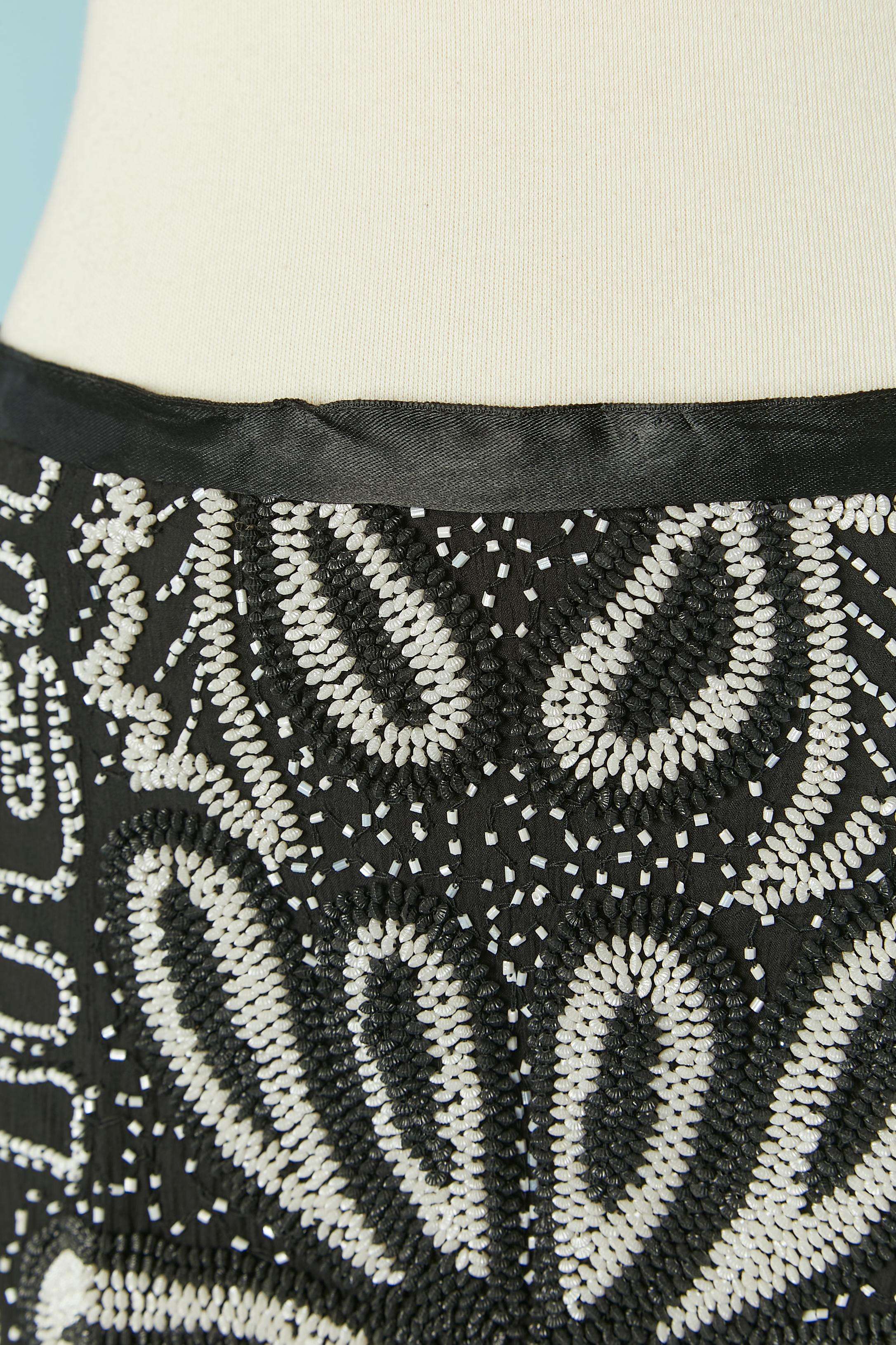 Long black evening skirt with white beaded work on a silk base. Acetate or rayon lining. Black ribbon satin waist band and gros-grain inside. Zip and hook&eye closure on the middle back. Split on the middle back, lenght : 44cm