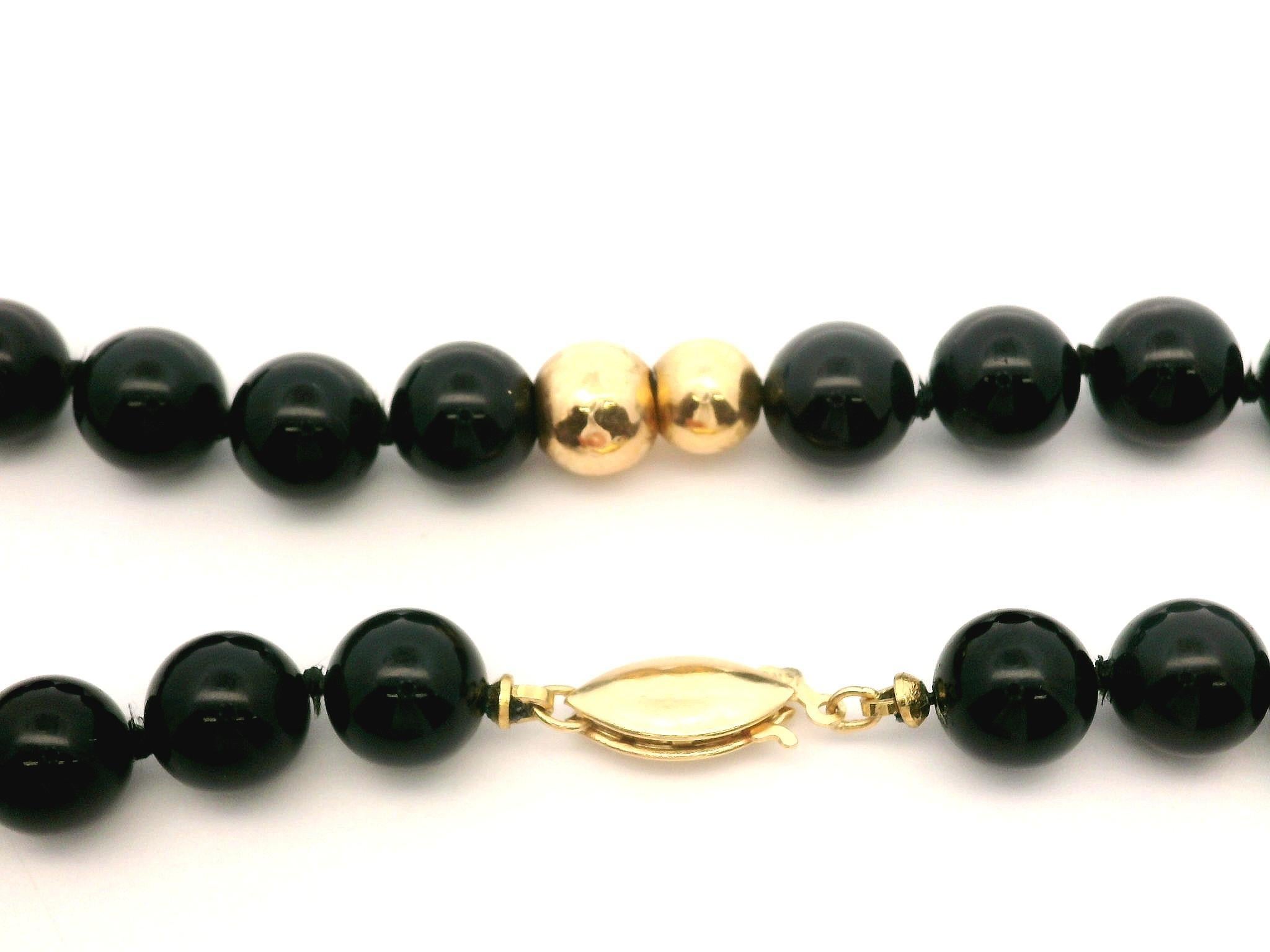 --Stone(s):--
Numerous Natural Genuine Onyx - Round Bead Cut - Strung - Pure Black Color - 7.7mm (approx.)

Material: String w/ 14k Yellow Gold Beads & Clasp
Weight: 44.61 Grams
Necklace Type: Strand w/ Polished Gold Beads Stations
Length: 28 Inches