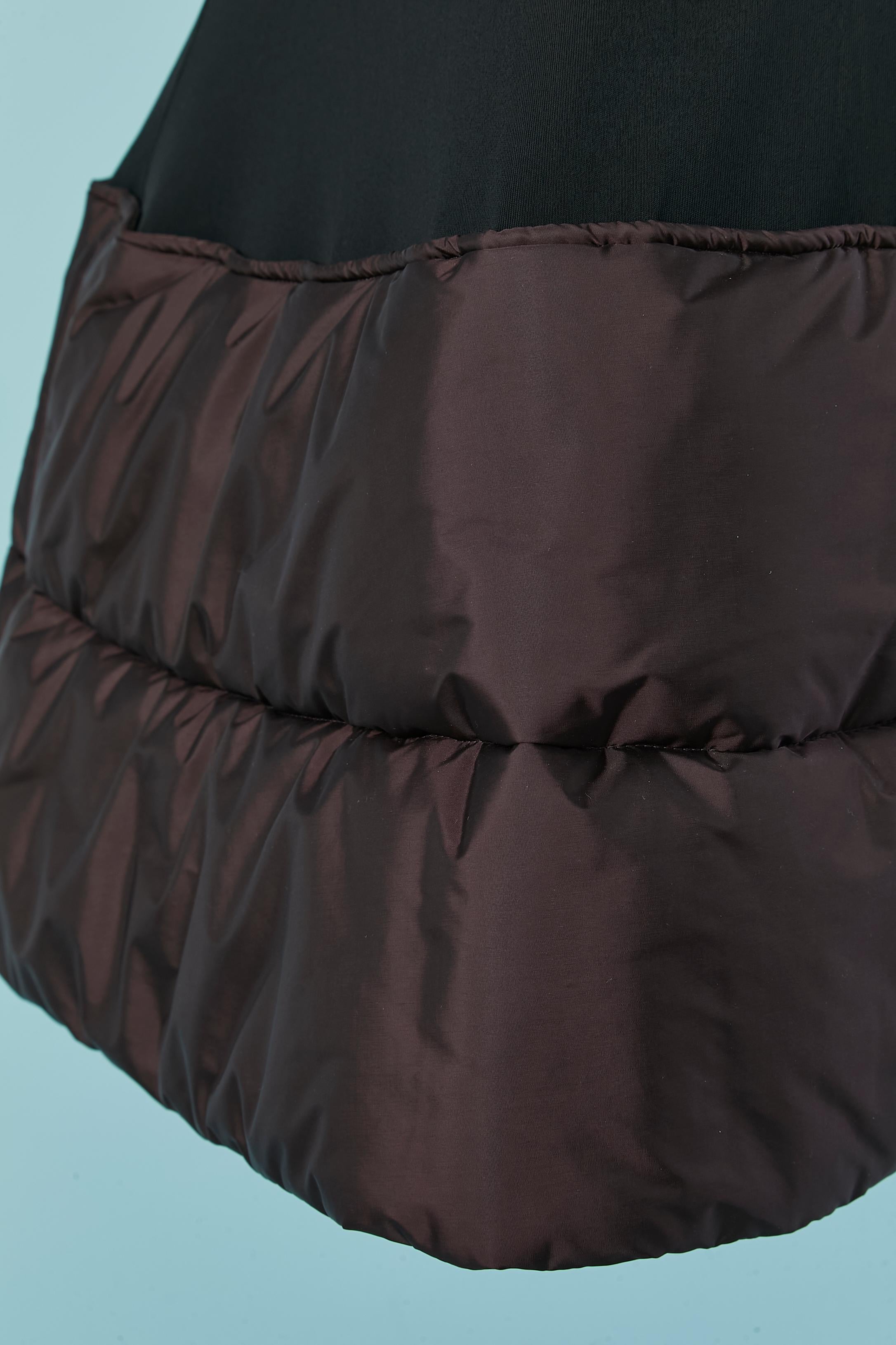 Long black skirt with brown padded edge. 
Black fabric composition: 100% rayon. Brown fabric ( on the bottom edge) : 91% polyamide, 9% polyurethane. Padding: 100% polyester. 
Invisible zip closure , button and buttonhole on the left side.
SIZE 42