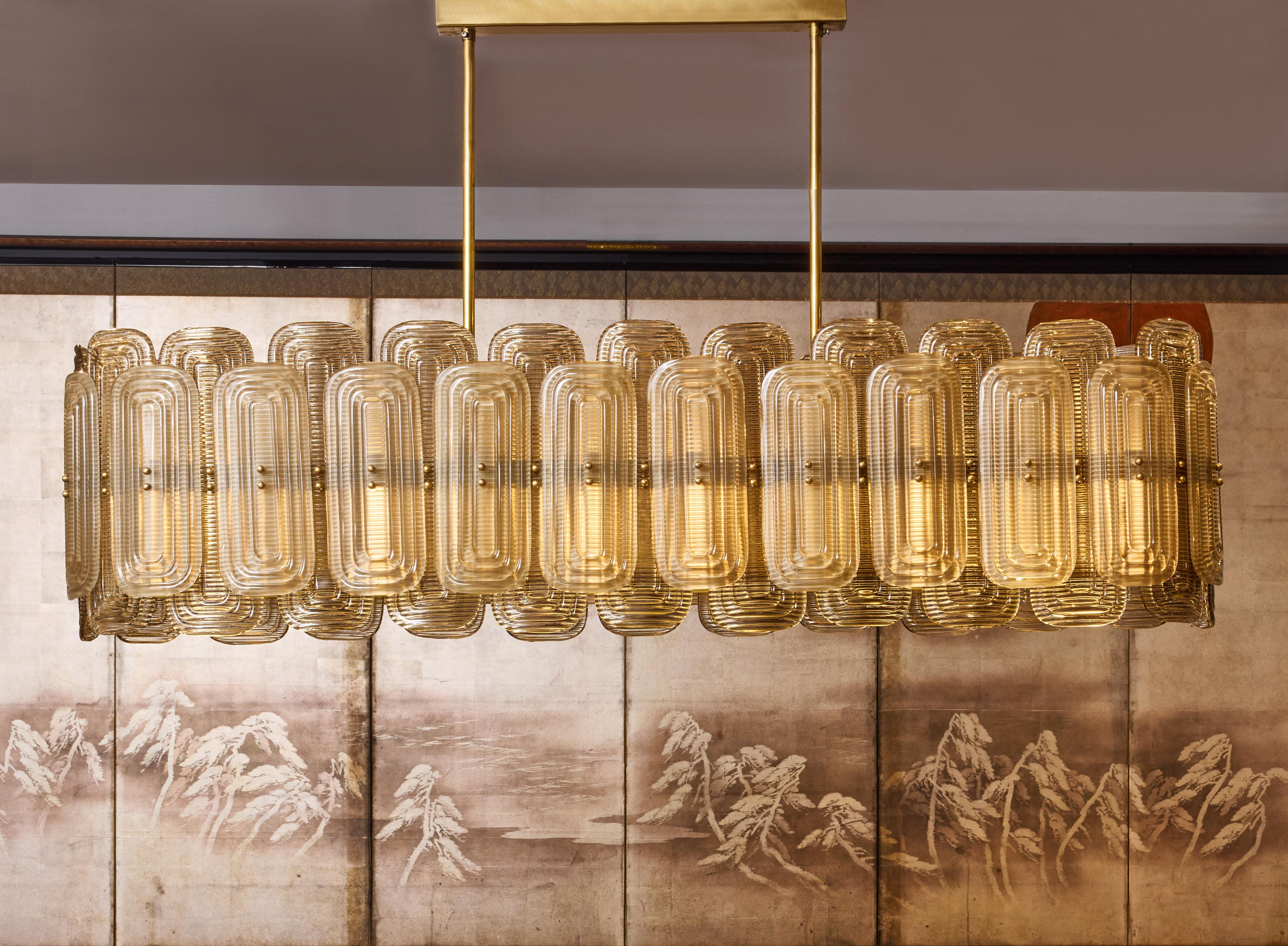 Long brass chandelier with sculpted Murano glass.
Italy, 2024.
