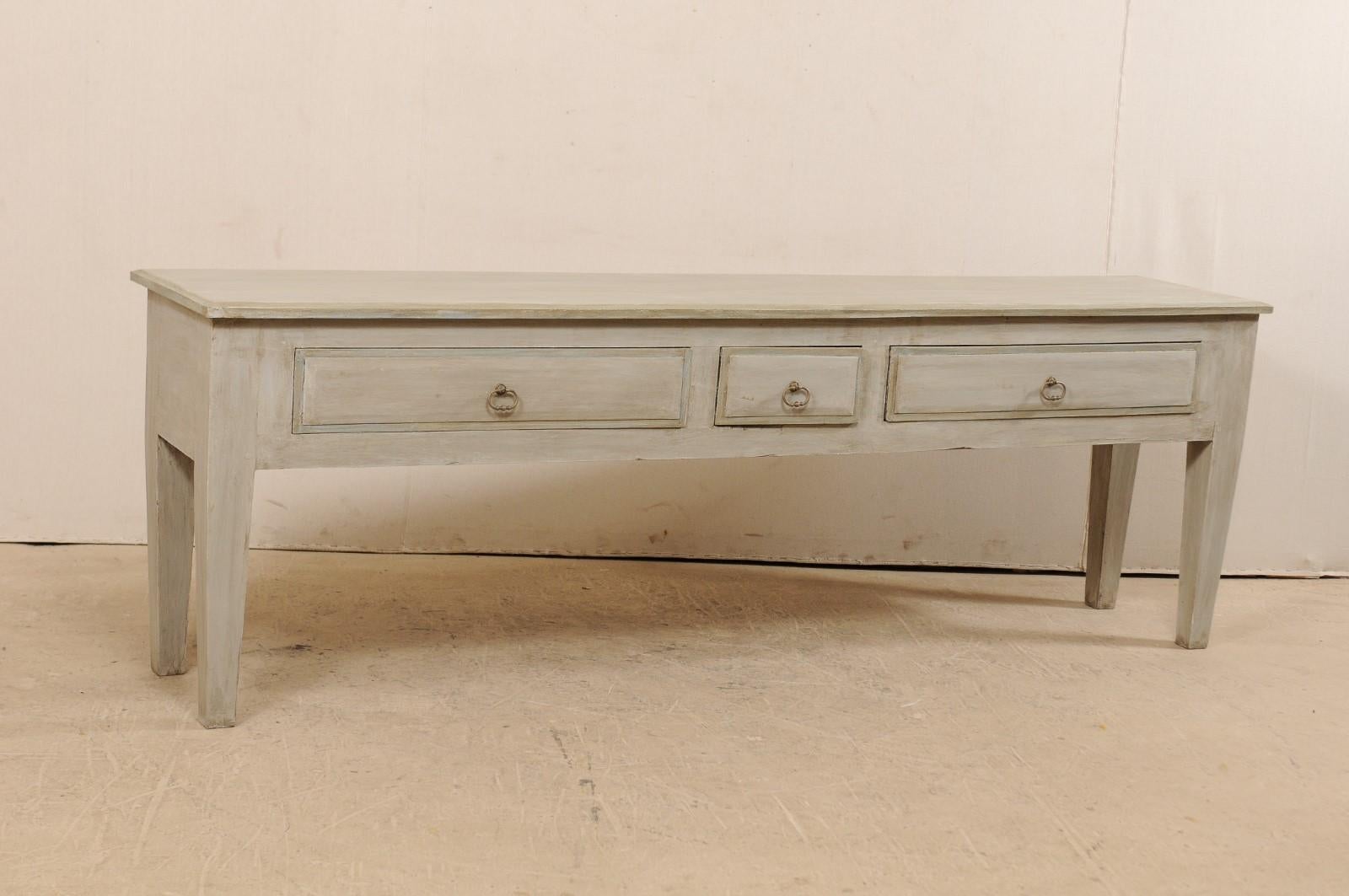 A long Brazilian painted wood console table with drawers, which has been fashioned from old, reclaimed wood. This Brazilian console table features a very pure and simple design. The 8+ foot long, rectangular-shaped top rests atop a plain skirt which
