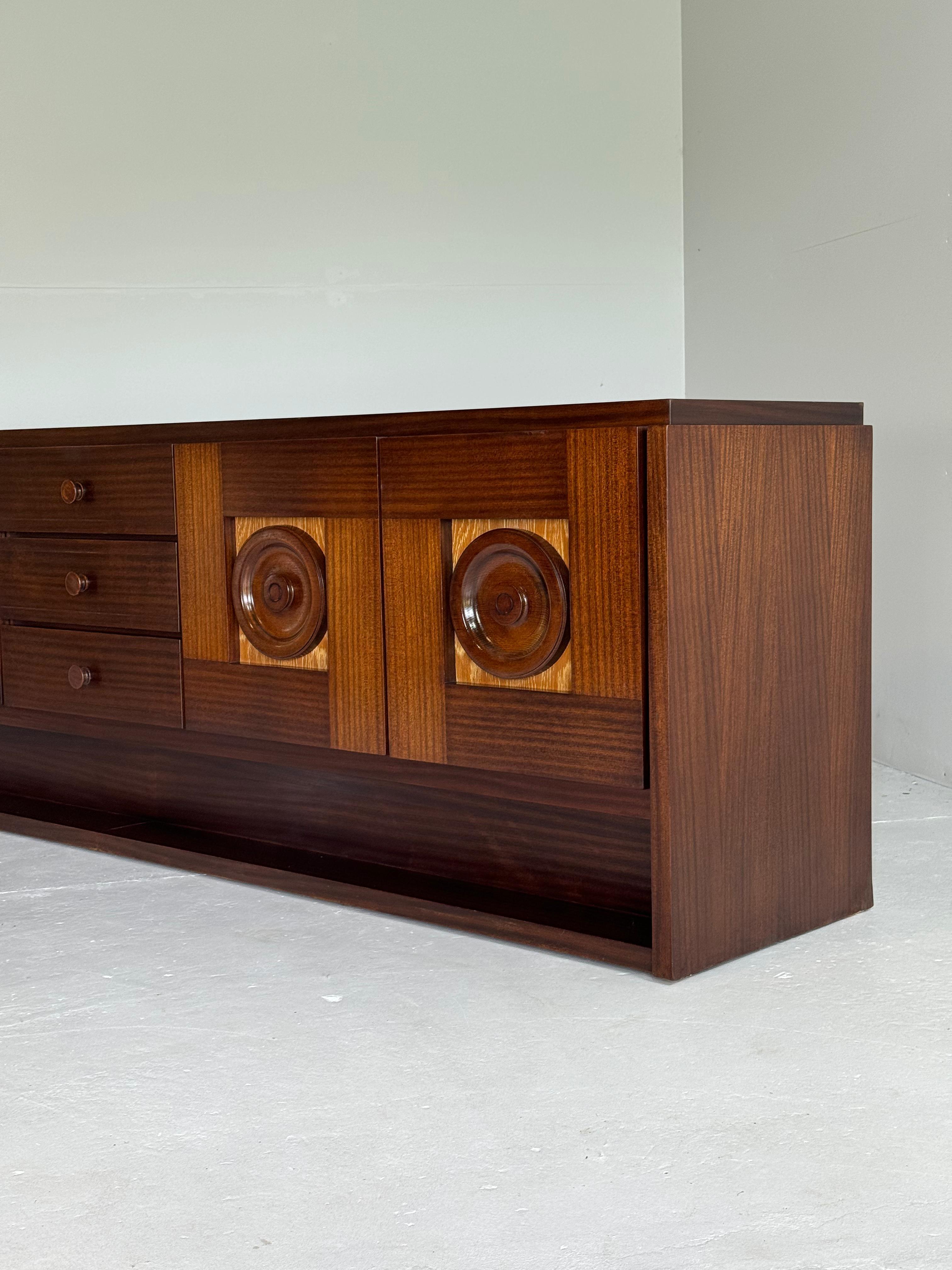 Very elegant and warm brown brutalist sideboard in oak.

Sideboard contains 4 opening doors with round graphical panel and 3 drawers centrated i the middle.

In absolute perfect and refinished condition.

Video on demand.

Matching Bar cabinet